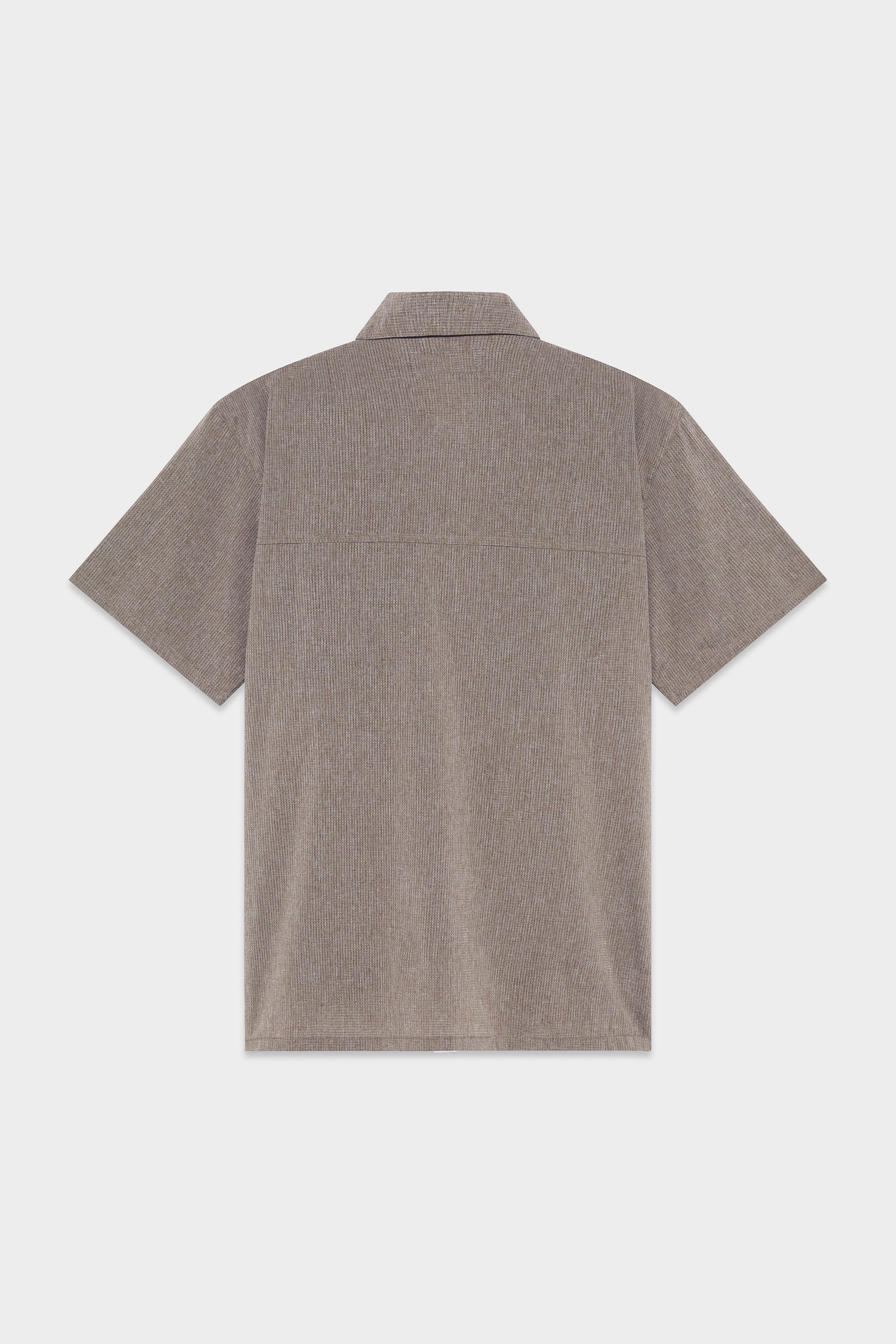 Back view of the 686 Mens Seeker Perforated Button Up, a short-sleeve, light brown textured shirt with a collar from 686, shown against a plain white background.