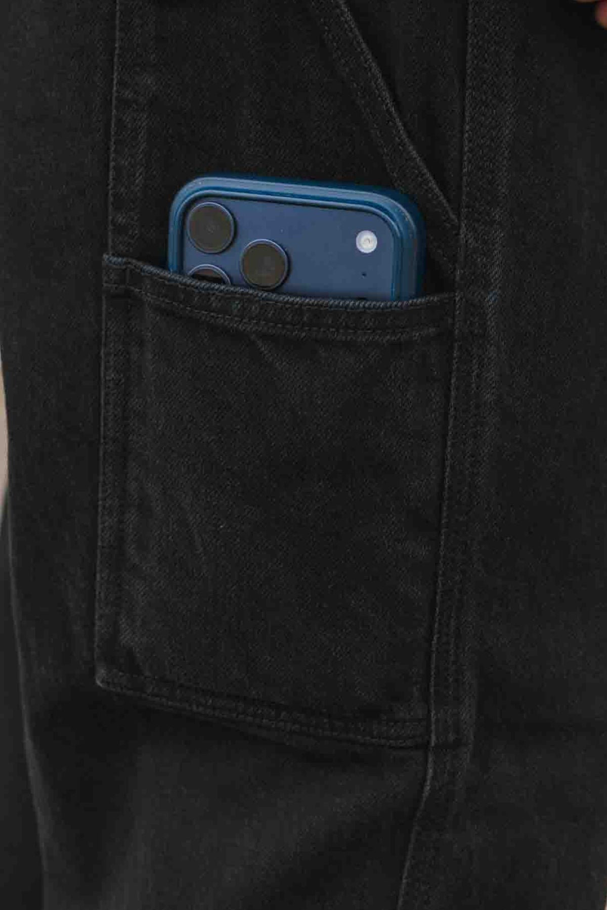 Blue smartphone tucked into the side pocket of 686 Men’s Unwork® Hammerhead Denim Pant.