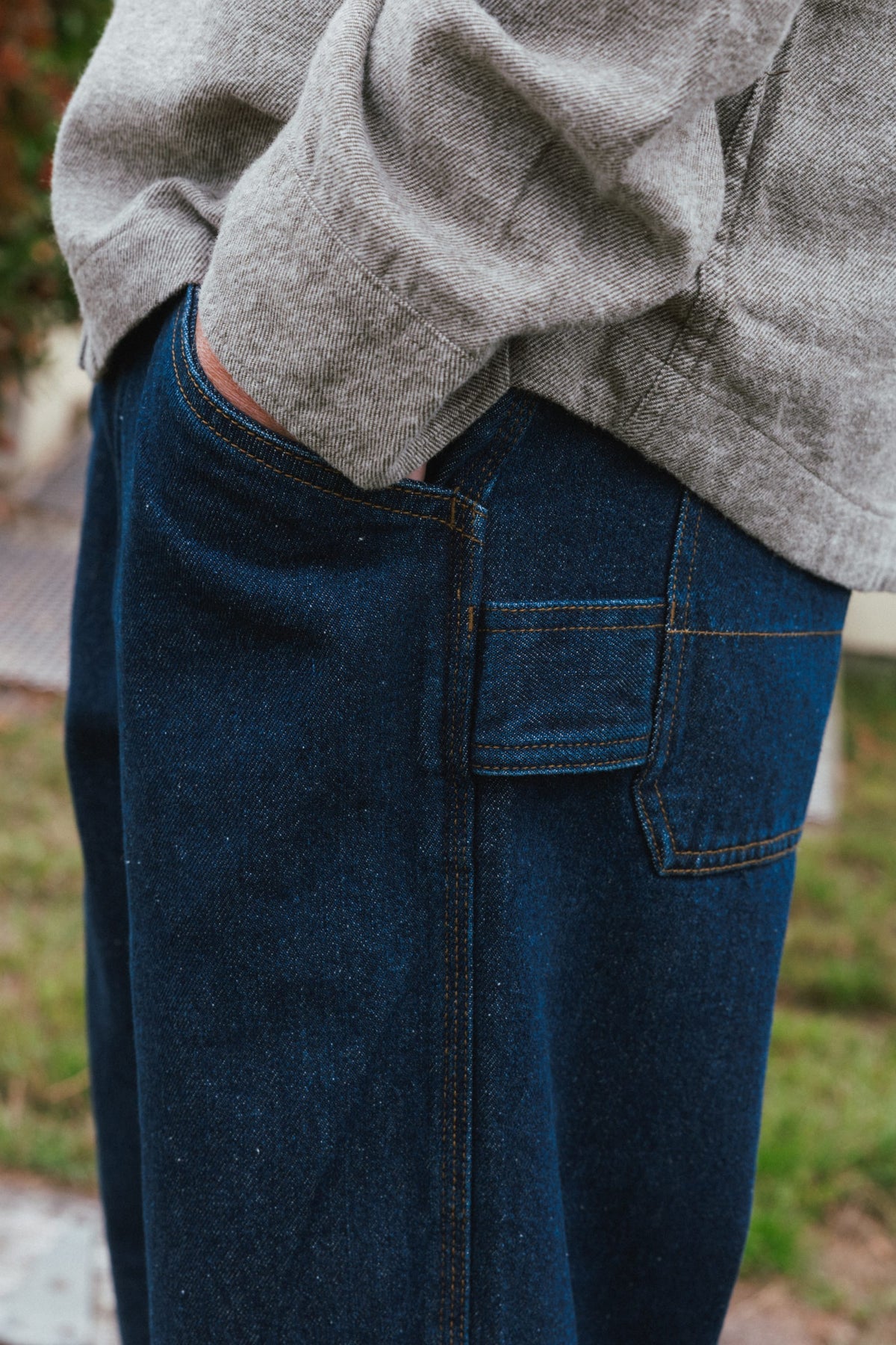Dark blue 686 Men’s Unwork® Hammerhead Denim Pant utility work jeans with reinforced side panels and a hand in the front pocket.