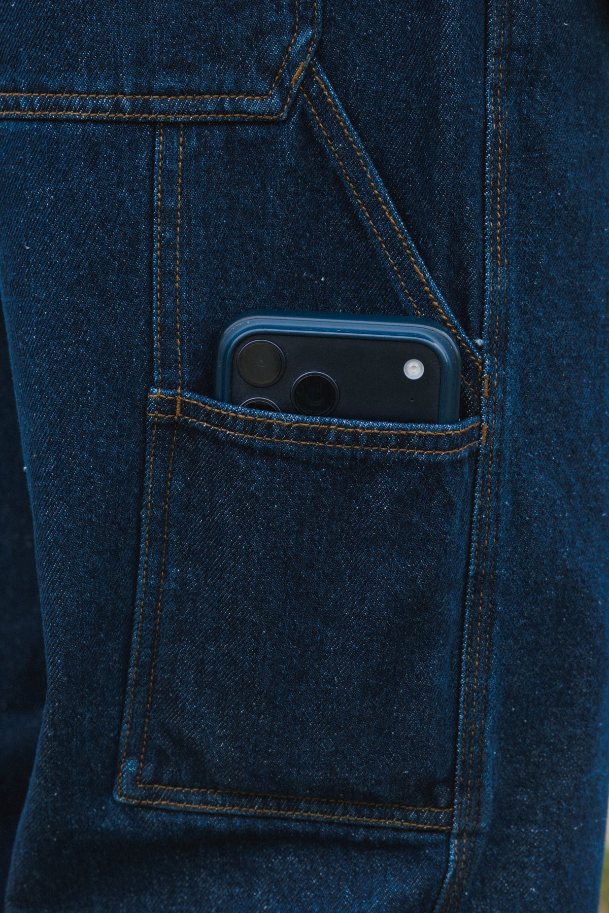 A smartphone tucked inside the pocket of 686 Men’s Unwork® Hammerhead Denim Pant utility work jeans.