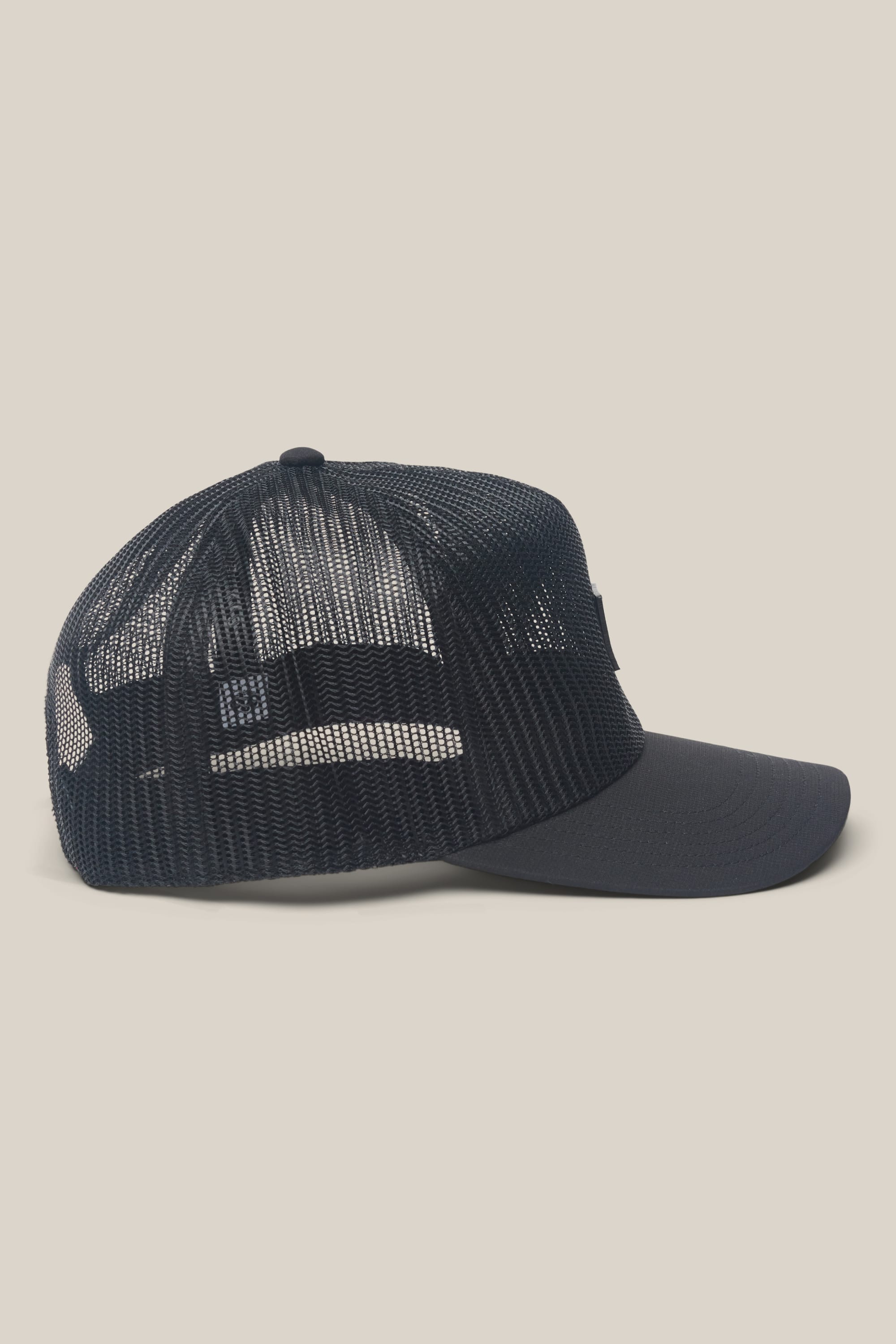 The 686 High-Pro Knockout Structured 5 Panel Hat by 686 is shown from the side against a plain beige background, featuring black mesh, a solid front panel, and a curved brim.