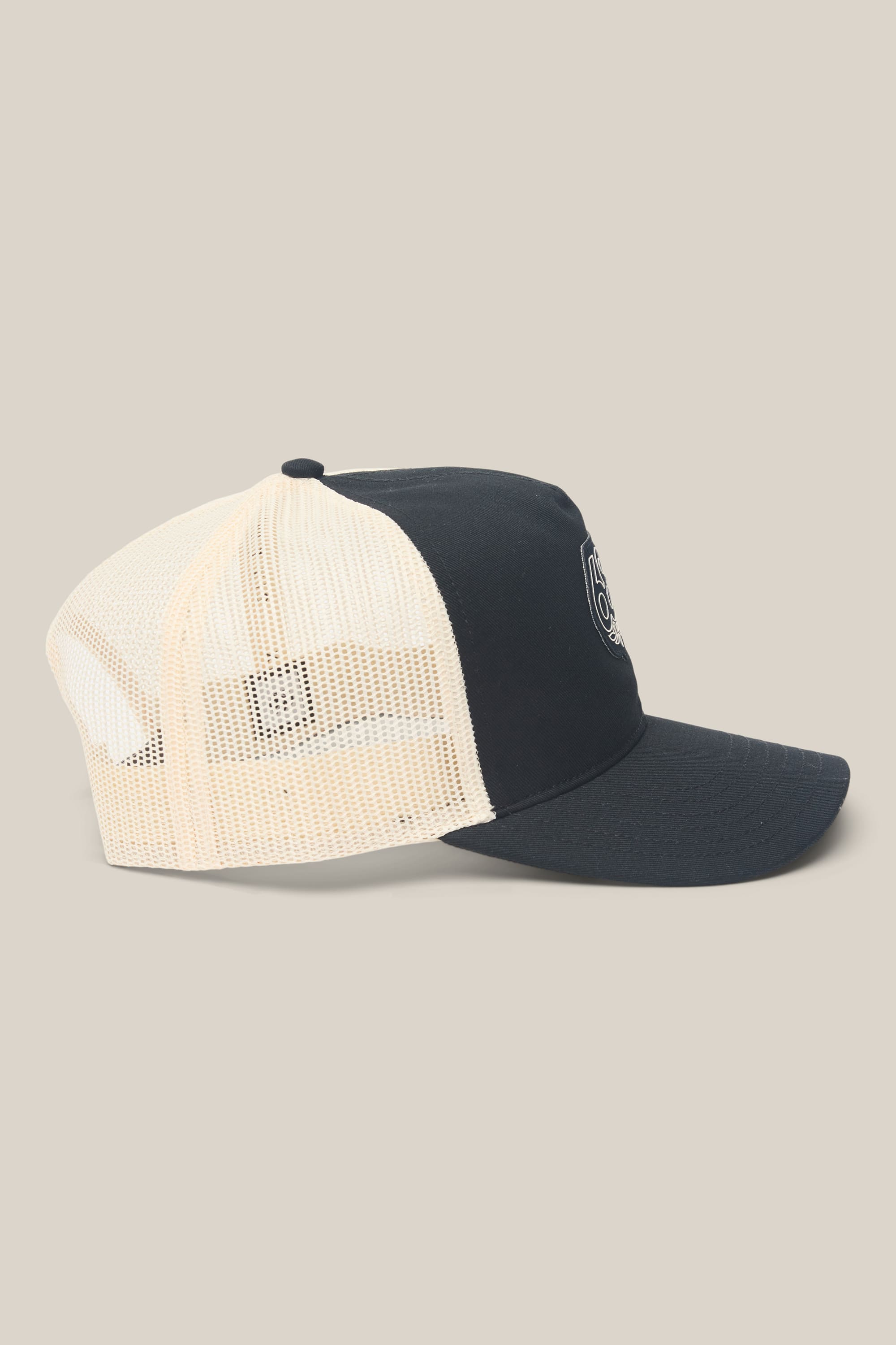The 686 Mid-Pro Wreath Unstructured 5 Panel Mesh Hat by 686 is a black and white trucker hat featuring a solid front panel with a small circular logo and a mesh back. Made from a durable polyester-cotton blend, this men's hat is displayed on a plain beige background.