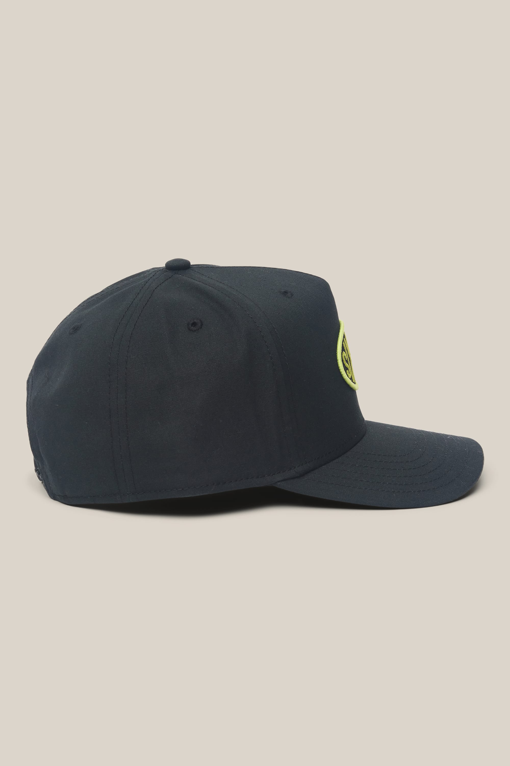 The 686 High-Pro 92 Structured 5 Panel Hat by 686, a black men's polyester-cotton cap, is shown in profile with a curved brim and yellow circular logo on the front panel, set against a plain beige background.