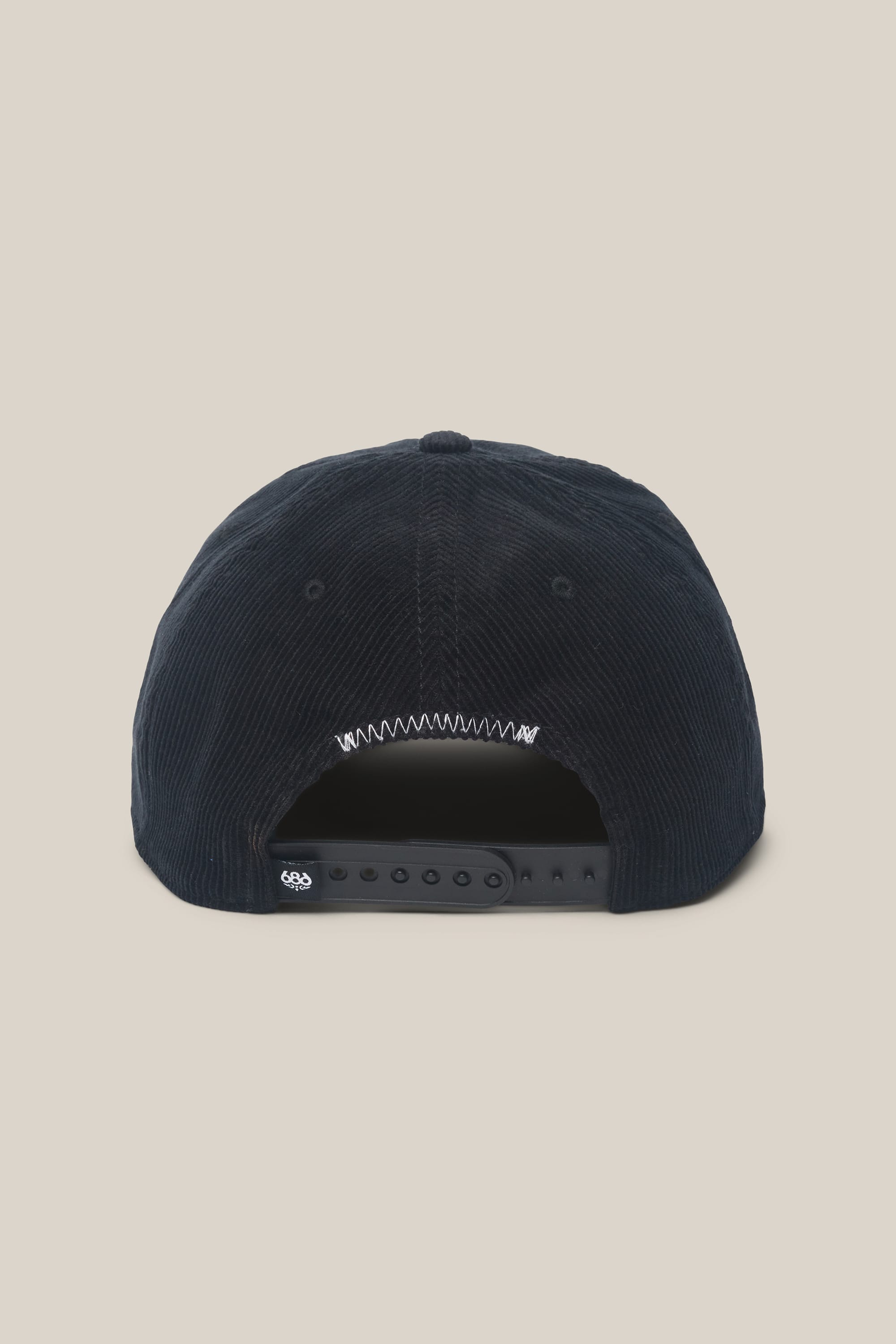 The 686 Mid-Pro Ghost Cord Unstructured 5 Panel Hat by 686 is shown from the back in navy blue corduroy, with a black adjustable snapback closure and a small logo on the strap, set against a plain beige background.