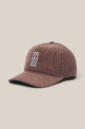 The 686 Mid-Pro Ghost Cord Unstructured 5 Panel Hat by 686 is a brown corduroy baseball cap featuring a curved brim and white geometric embroidery, shown on a light beige background.