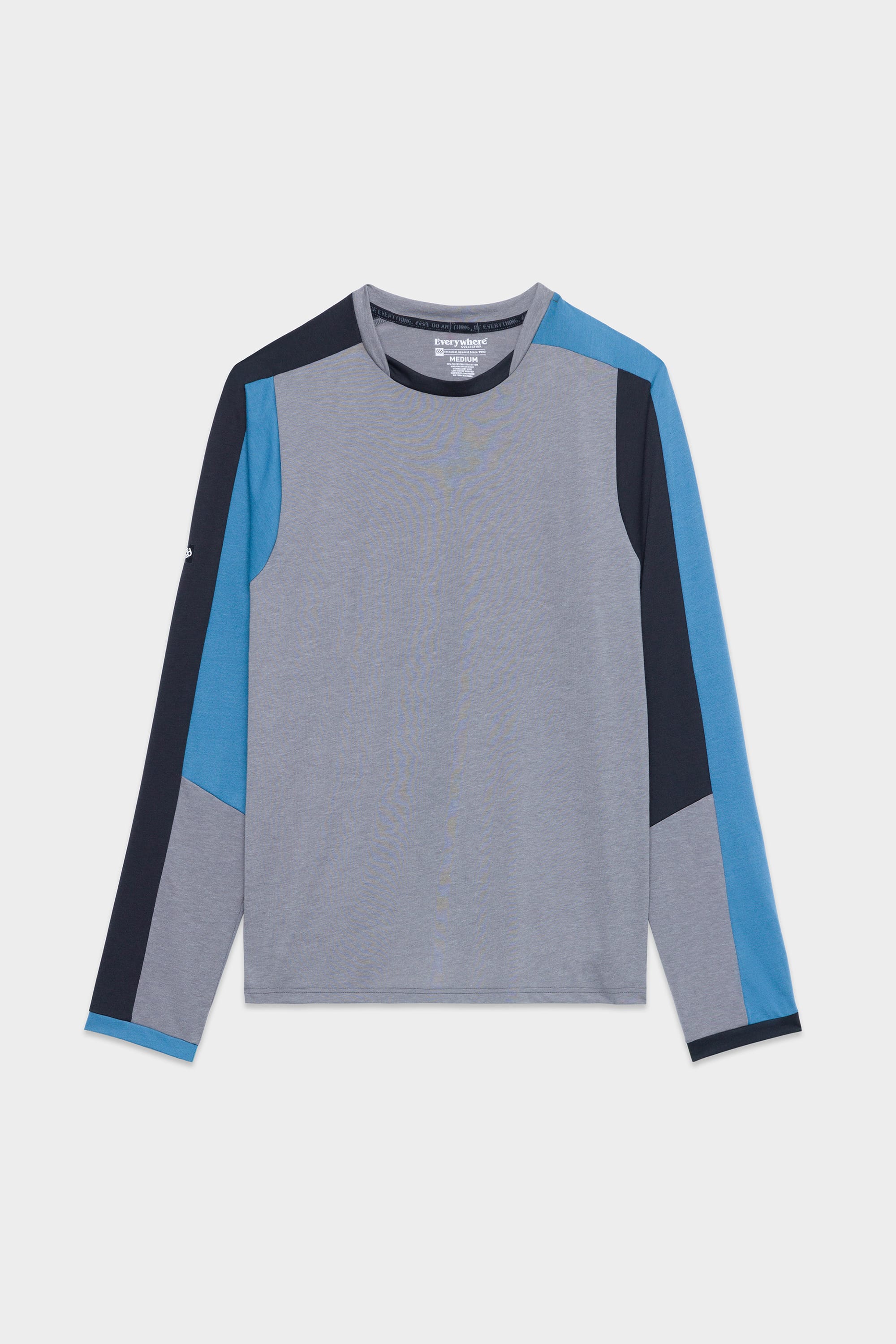 The 686 Mens Rival Long Sleeve Bike Jersey features color-blocked panels on the sleeves and shoulders in gray, blue, and navy, plus a crew neck for a modern geometric style.