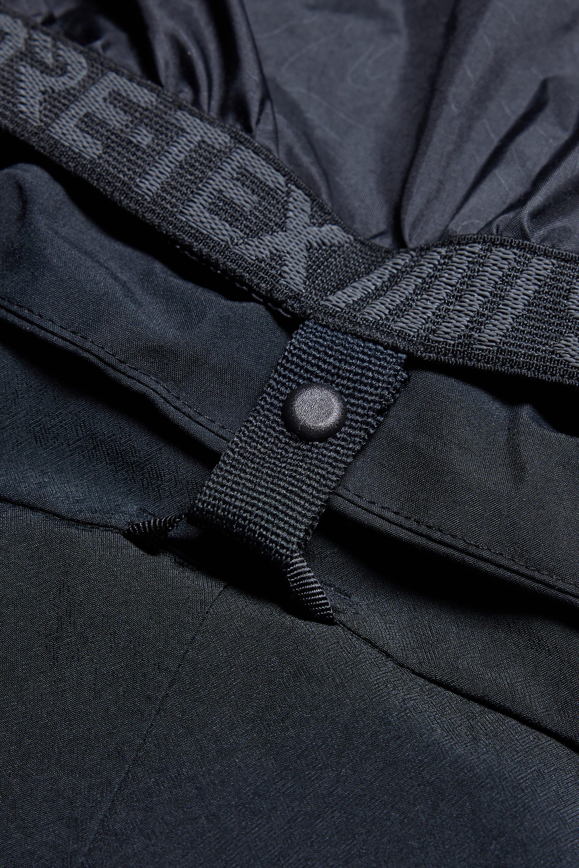 Close-up of the 686 Men's SMARTY® 3-in-1 Cargo Pant shows the waistband with GORE-TEX text, a snap button on a fabric loop, and detailed stitching—with a removable sweatpant liner for three ways to wear.