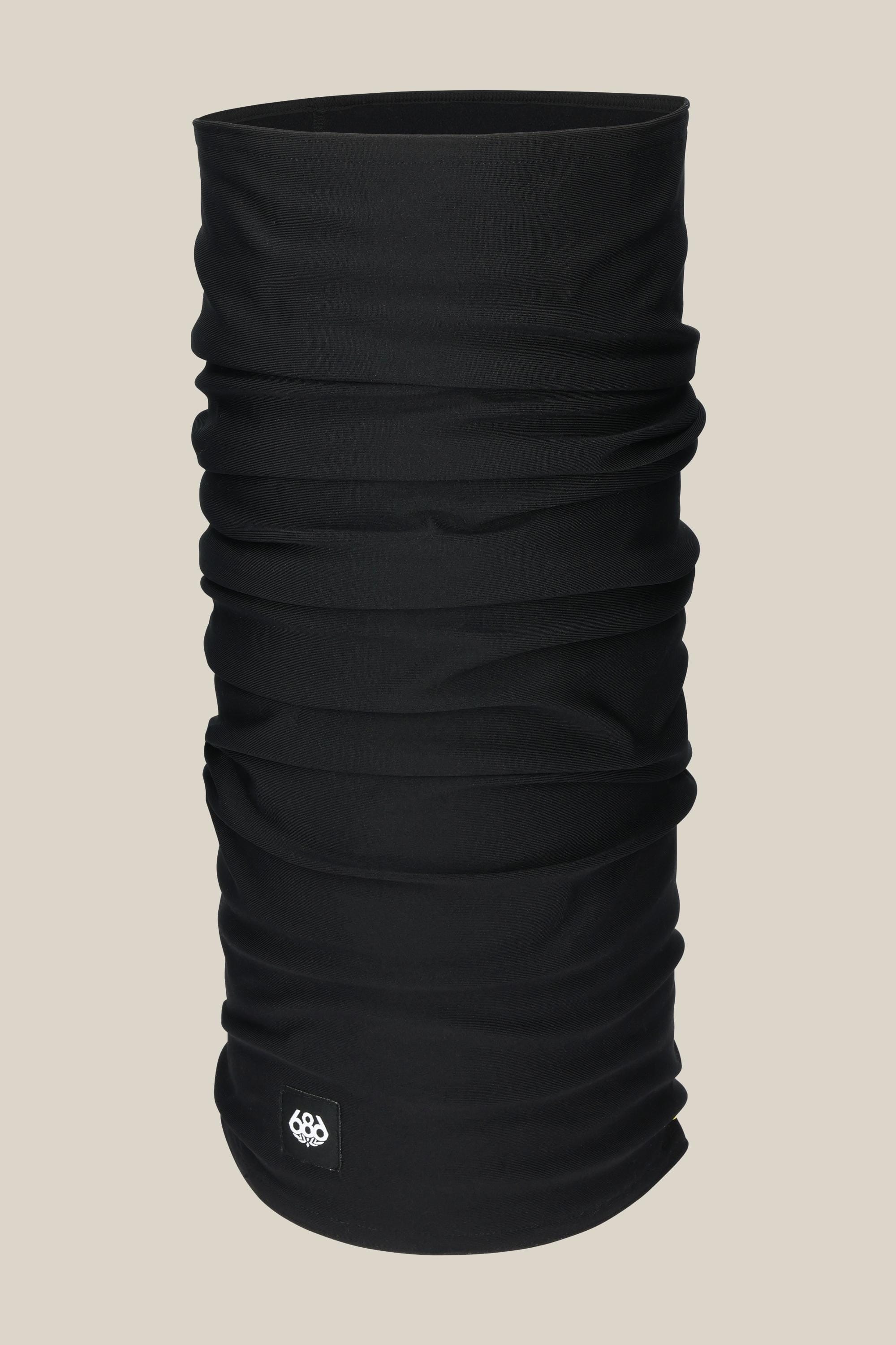 The 686 Double Layer Face Warmer by 686 is a black, tubular neck gaiter made of stretchy fabric with subtle wrinkling and a small rectangular logo patch near the bottom edge, displayed against a light beige background.