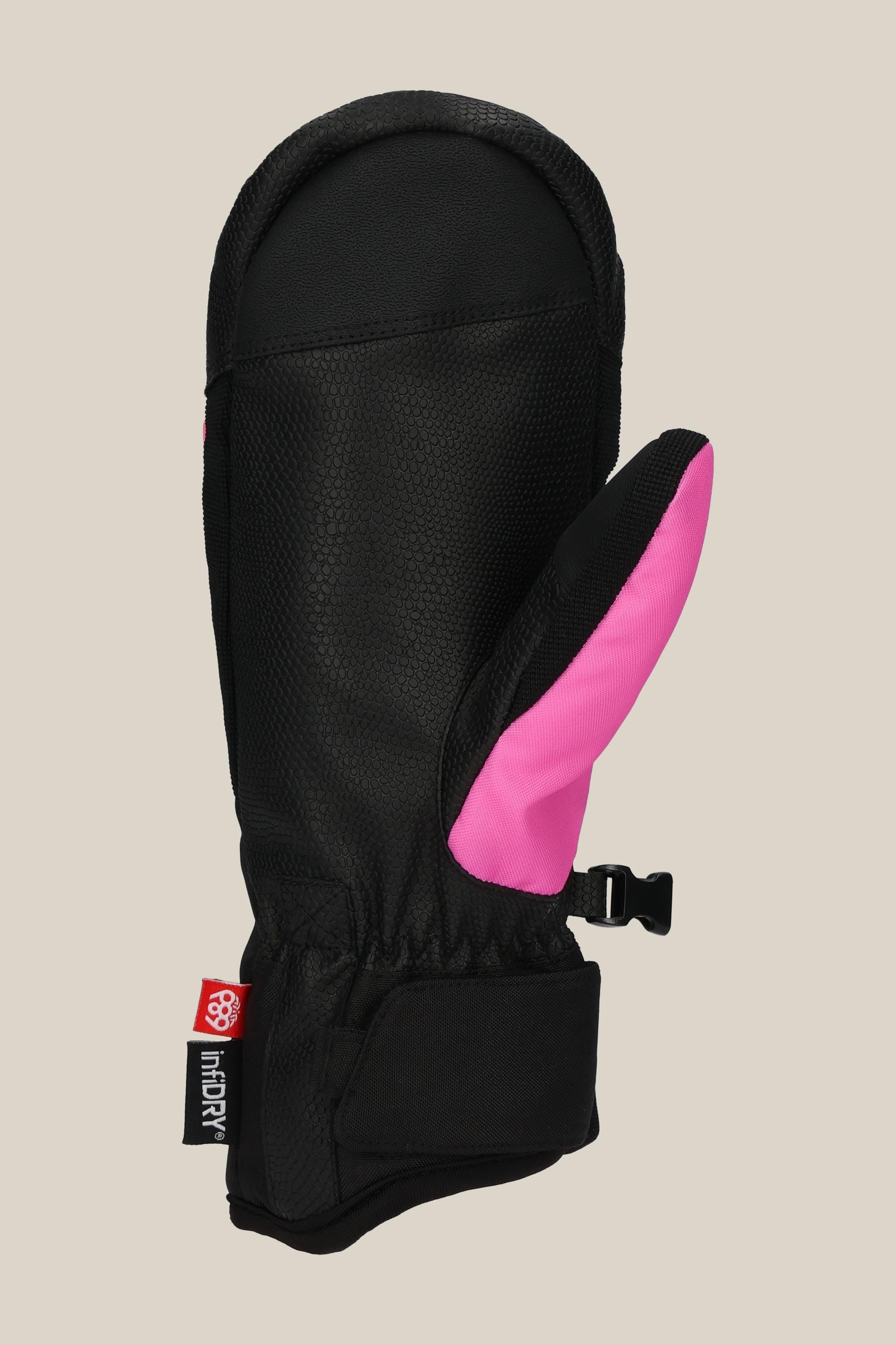 The 686 Womens Revel Mitt by 686 is a black insulated mitt with a bright pink thumb, adjustable wrist strap, black clip, and a red and white fabric tag near the wrist. Shown against a light beige background.