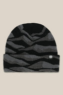The 686 Summit Beanie by 686 features a black and dark gray wavy striped design with a small white logo patch on the folded brim, shown on a beige background—ideal for adventurous climbs or epic descents.