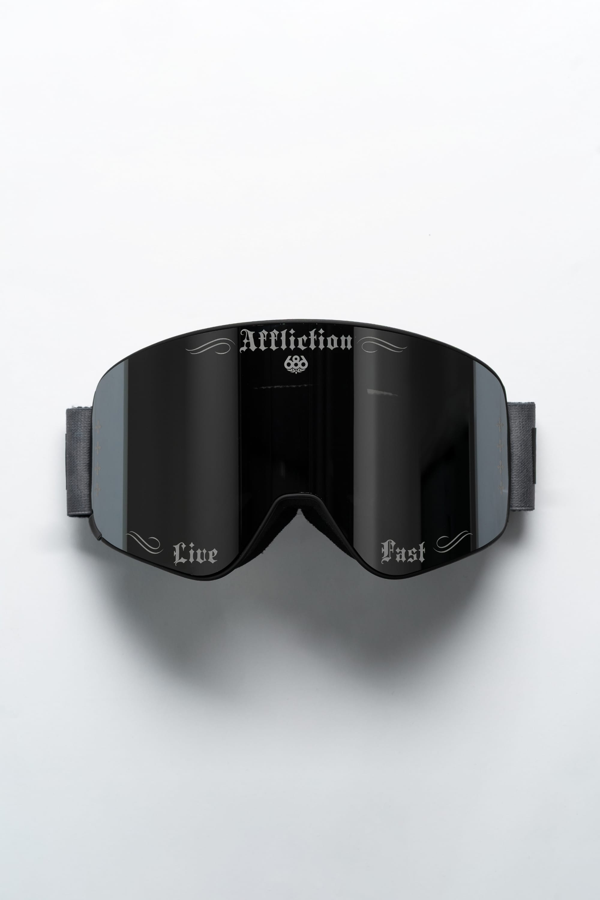 The 686 SMARTY® Magnetic Goggle by 686 features black frames, reflective lenses, and gothic lettering: "Affliction" at the top center, "Live" on the left lens, and "Fast" on the right—all set against a white background.