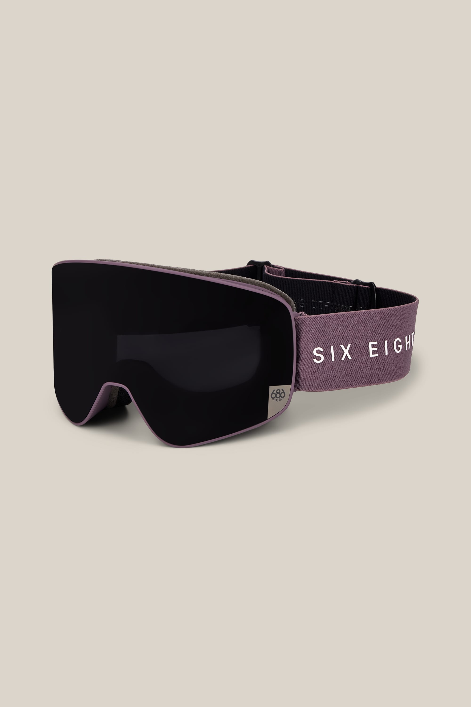 The 686 SMARTY® Magnetic Goggle by 686 features a purple frame with a black lens and an adjustable strap displaying “SIX EIGHT” in white letters. The goggles are set against a plain, light beige background.