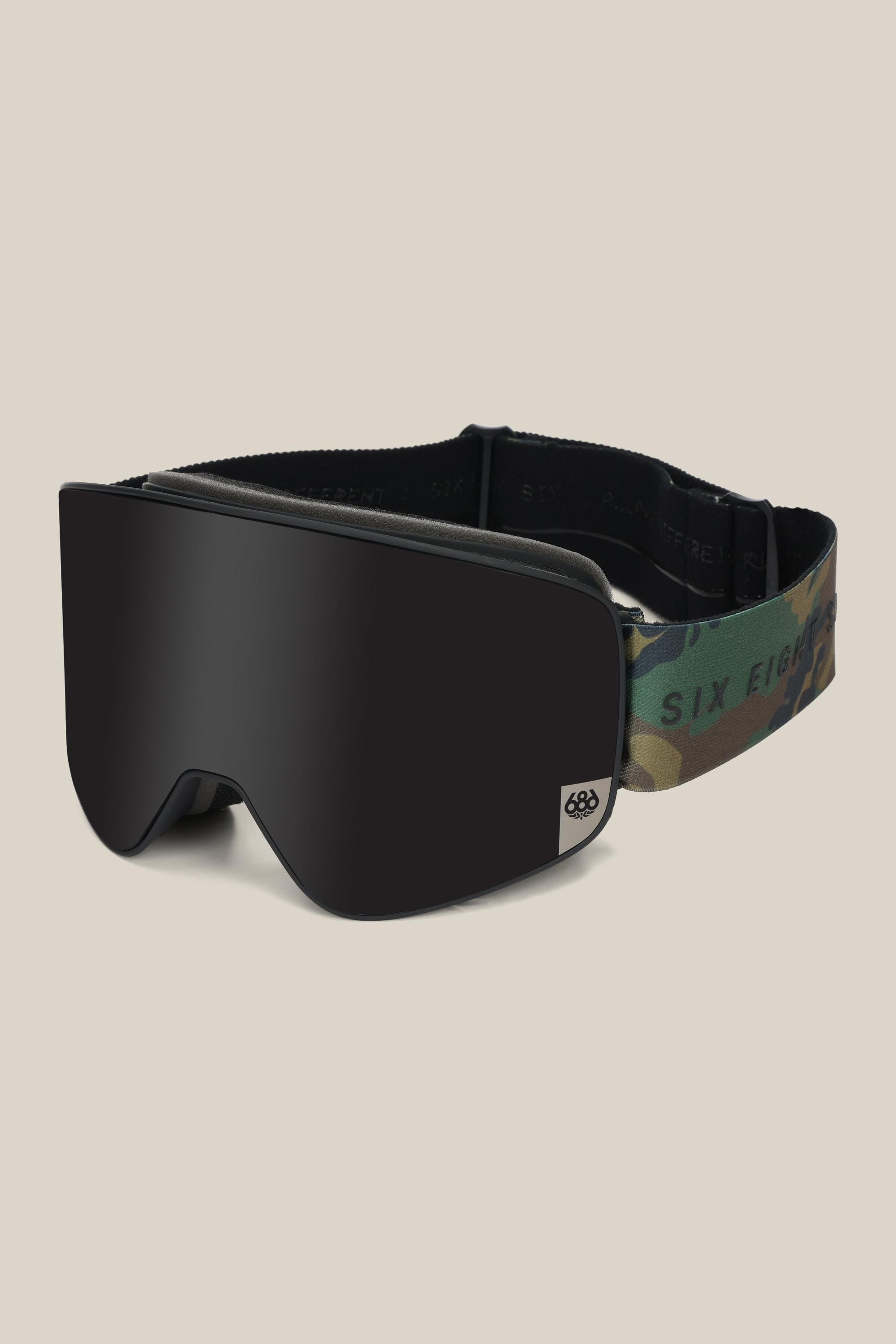 The 686 SMARTY® Magnetic Goggle by 686 features a sleek black minimalist design, dark tinted lens, and a camouflage-patterned adjustable strap with SIX EIGHT branding. Magnetic lenses make swapping them fast and easy.
