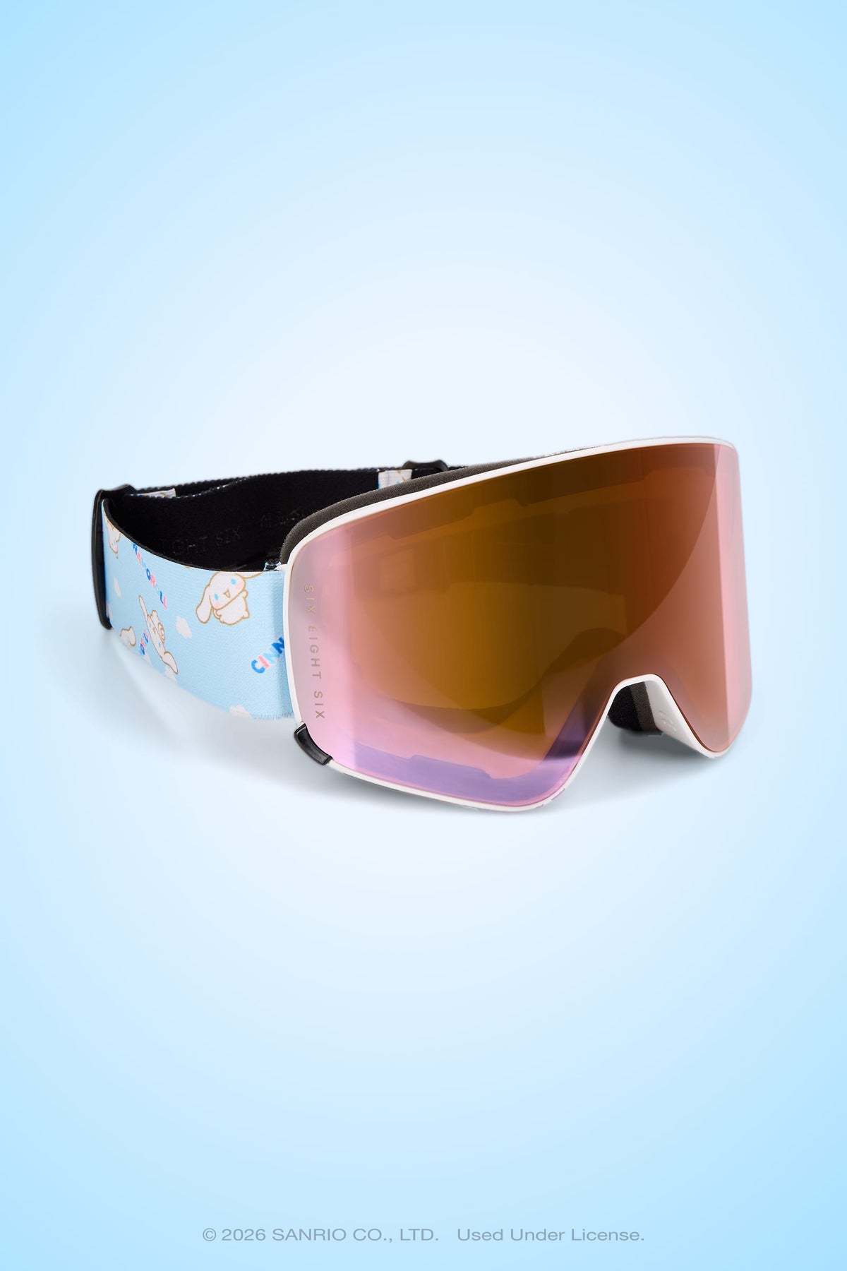 The 686 SMARTY® Magnetic Goggle from 686 features a reflective magnetic lens for full-lens vision and comes with a light blue strap decorated with small white character illustrations, shown against a light blue background.