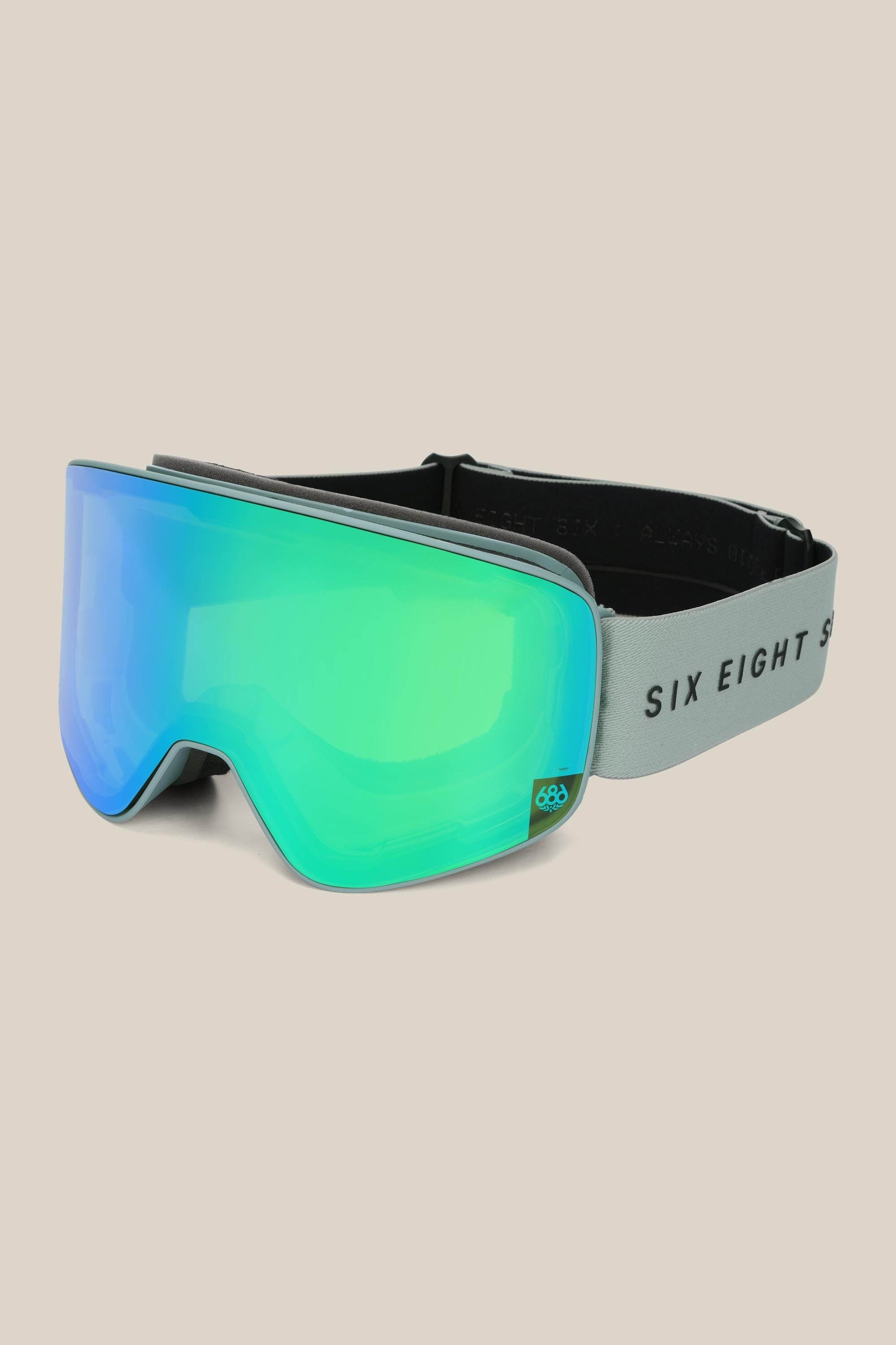 The 686 SMARTY® Magnetic Goggle by 686 features a reflective green magnetic lens and a grey adjustable strap with SIX EIGHT SIX branding, shown on a light beige background.