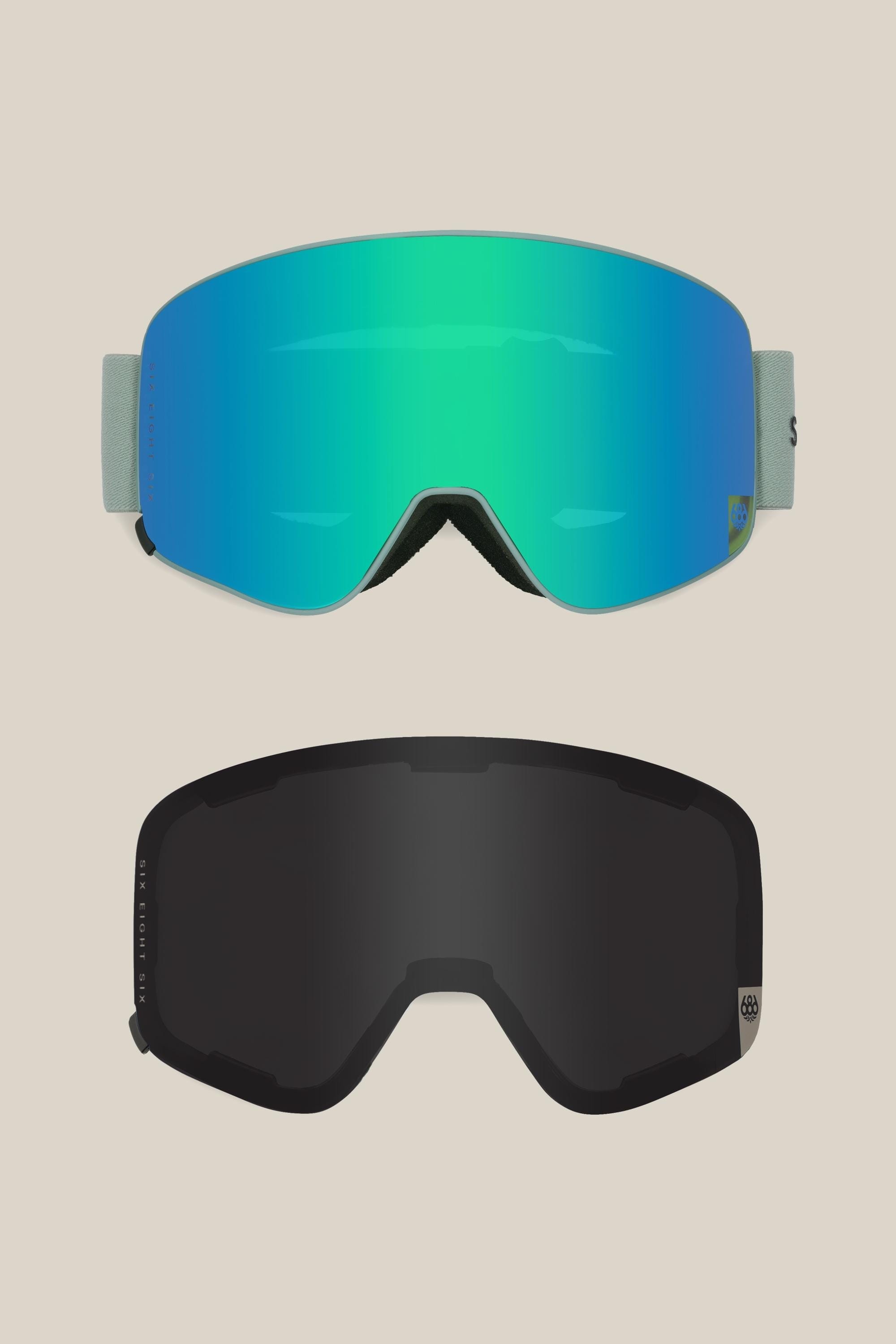 Two 686 SMARTY® Magnetic Goggles by 686 are shown: the top has a reflective blue-green lens with a light gray strap, and the bottom has a dark black lens. Both minimalist goggles with magnetic lenses are set on a light beige background.