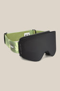 The 686 SMARTY® Magnetic Goggle by 686 features a black minimalist frame, wide dark lens, and a green adjustable strap with a marijuana leaf print and the HUF logo. Its magnetic system enables fast, easy lens changes. Displayed on a plain beige background.