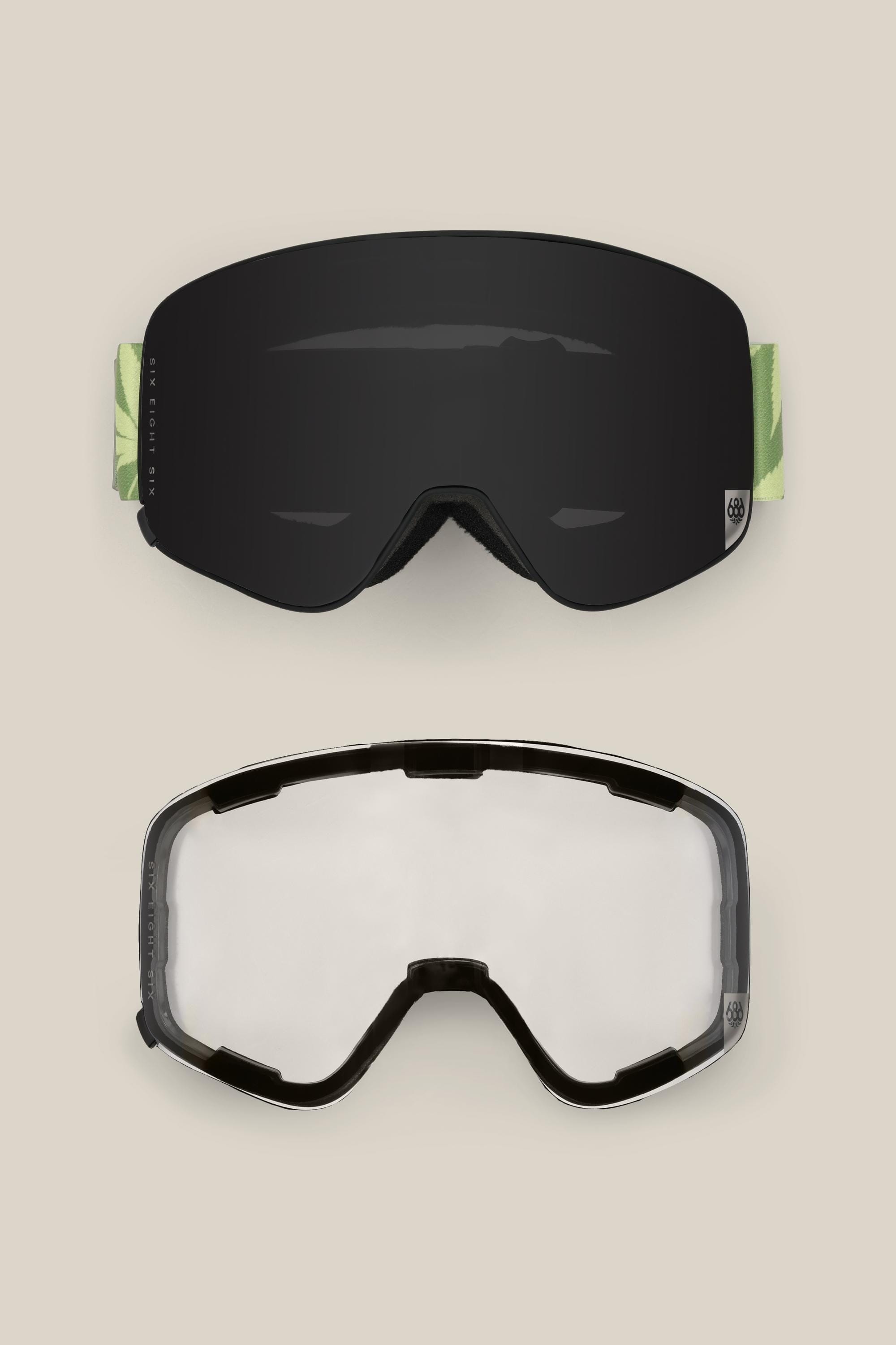 Two pairs of 686 SMARTY® Magnetic Goggles are displayed on a beige background: the top pair has a dark reflective lens with green side straps, while the bottom pair features a clear lens with a black frame.