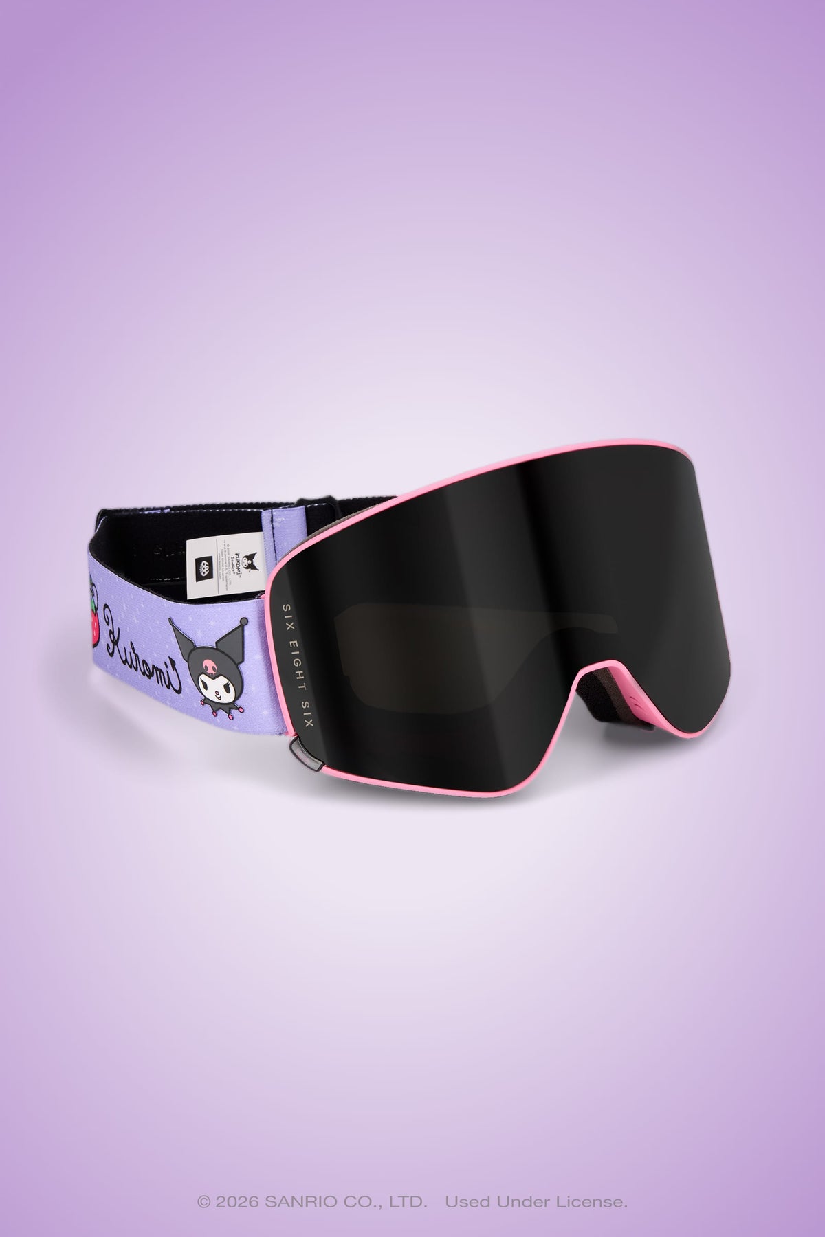 The 686 SMARTY® Magnetic Goggle by 686 features a black lens with stylish purple and pink accents, Kuromi character art, and Kuromi text on the strap—delivering full-lens vision for every adventure. Shown against a light purple backdrop.