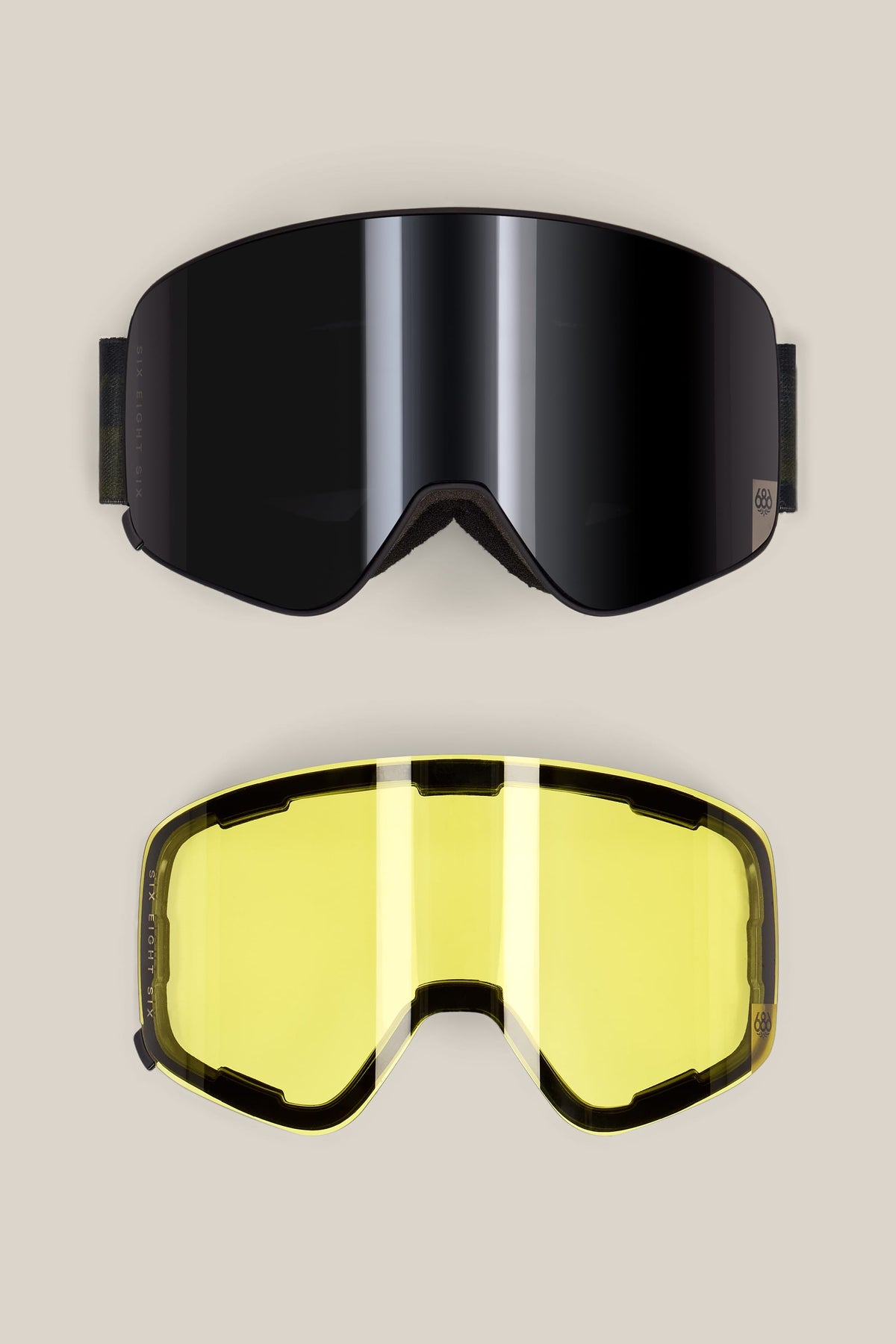 Two 686 SMARTY® Magnetic Goggle pairs, one with a dark mirrored lens and the other with a yellow lens, both featuring black frames and magnetic lenses on branded, oversized straps.