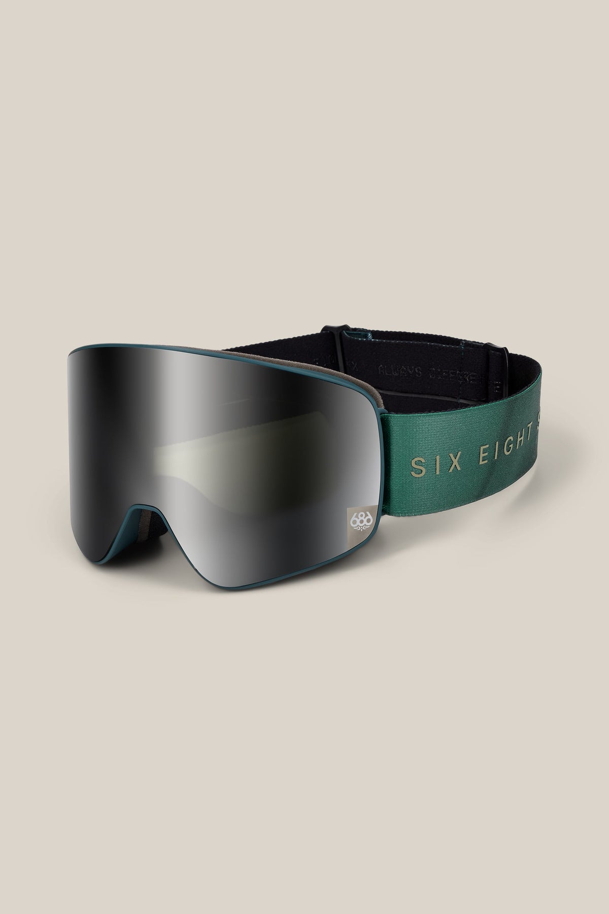 The 686 SMARTY® Magnetic Goggle features a reflective, frameless lens and a green elastic strap adorned with the text SIX EIGHT. The product is set against a plain light beige background.