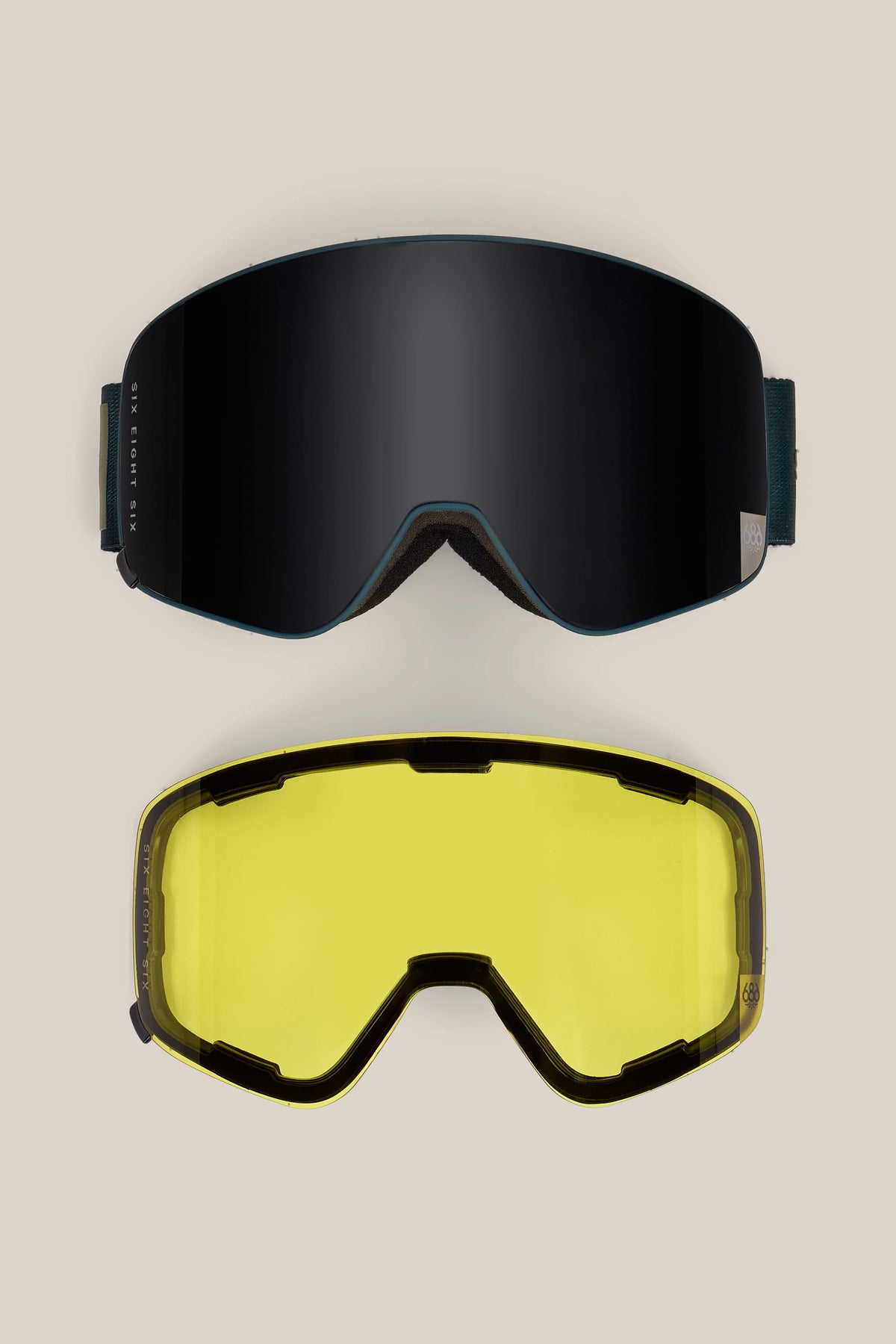 Two 686 SMARTY® Magnetic Goggles by 686 are displayed against a plain, light background: the top features a dark, reflective lens, while the bottom showcases a yellow-tinted lens.