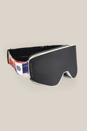 The 686 SMARTY® Magnetic Goggle by 686 features a sleek black minimalist design, a wide frameless lens, and a patterned strap with a white logo tag, shown against a plain beige background.