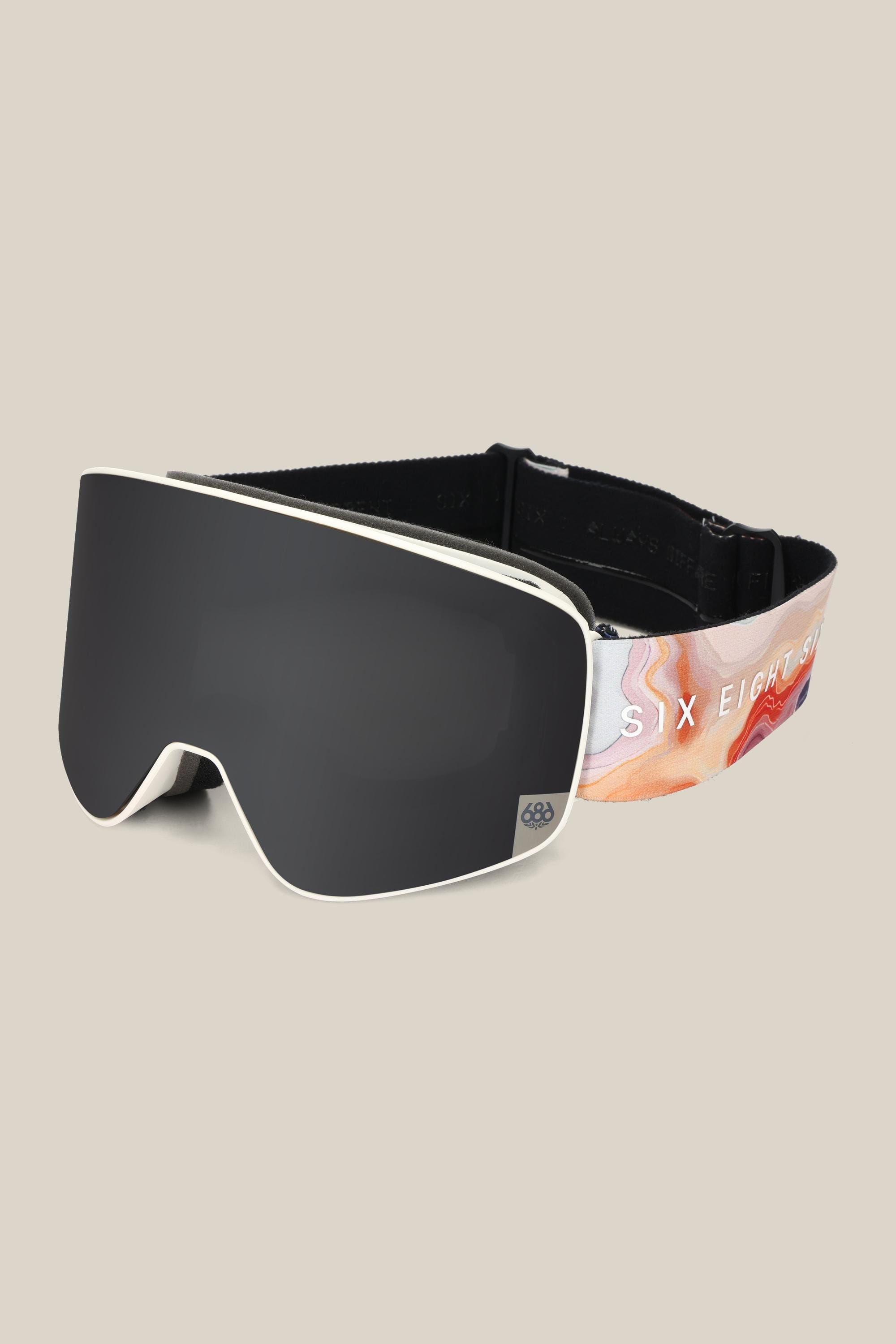 The 686 SMARTY® Magnetic Goggle features a sleek black minimalist design, a reflective interchangeable lens, and a colorful strap with "686" in white on a light beige background.