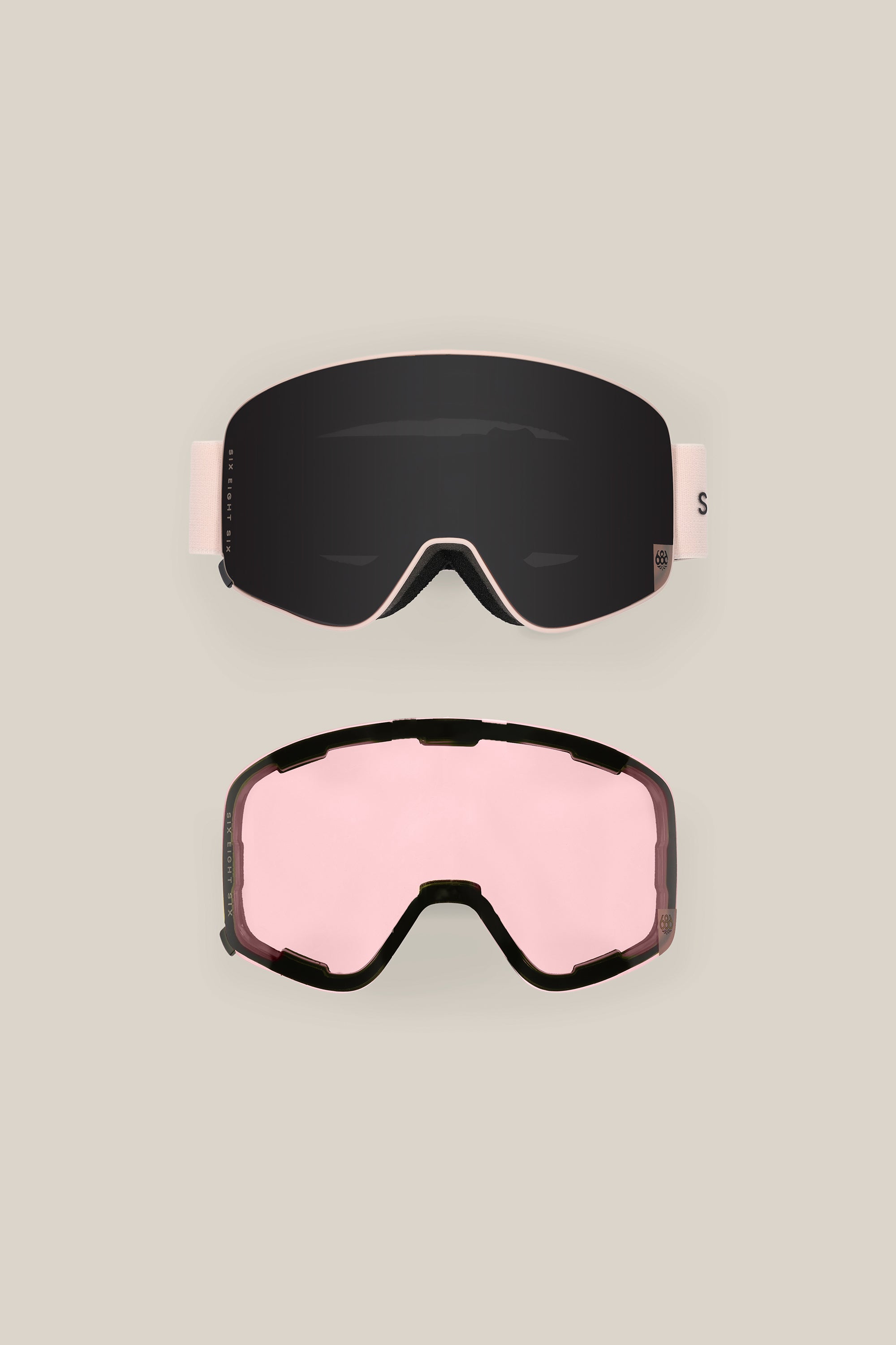 The 686 SMARTY® Magnetic Goggle by 686, shown on a beige background, features two interchangeable lenses: one with a dark tint and white strap, and another with a pink tint and black frame.