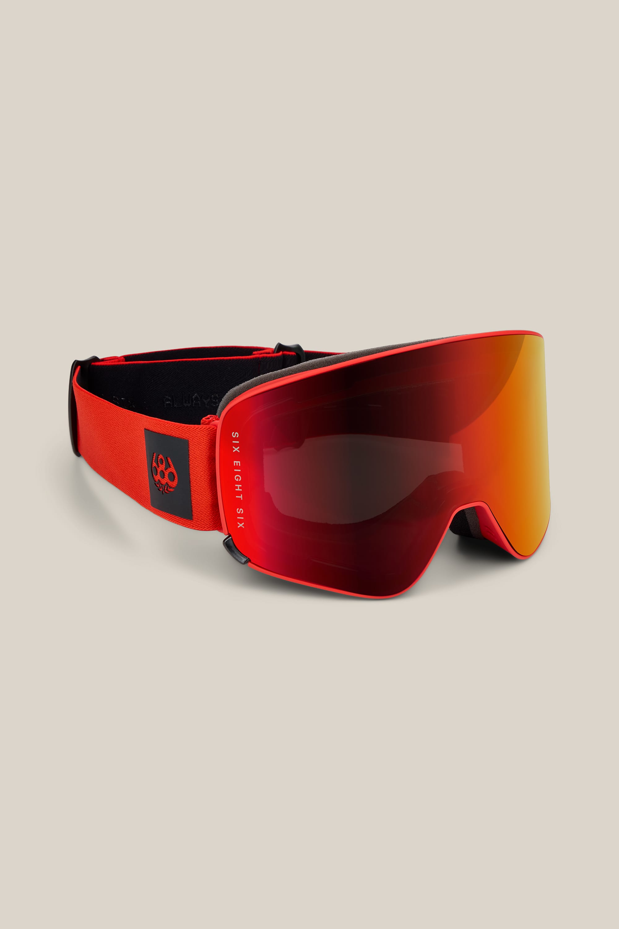 The 686 SMARTY® Magnetic Goggle by 686 features a wide, mirrored lens and an adjustable strap. The strap is accented with a small black patch displaying a white logo. Set against a light beige background.
