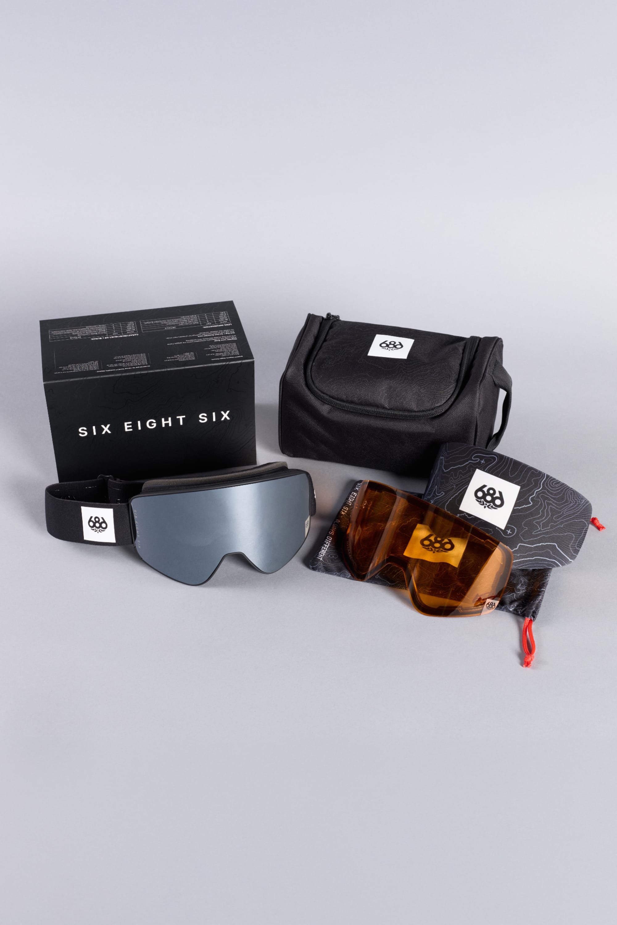The 686 SMARTY® Magnetic Goggle by 686 is displayed on a light gray background with two interchangeable lenses, a carrying case, a pouch, and a branded box.