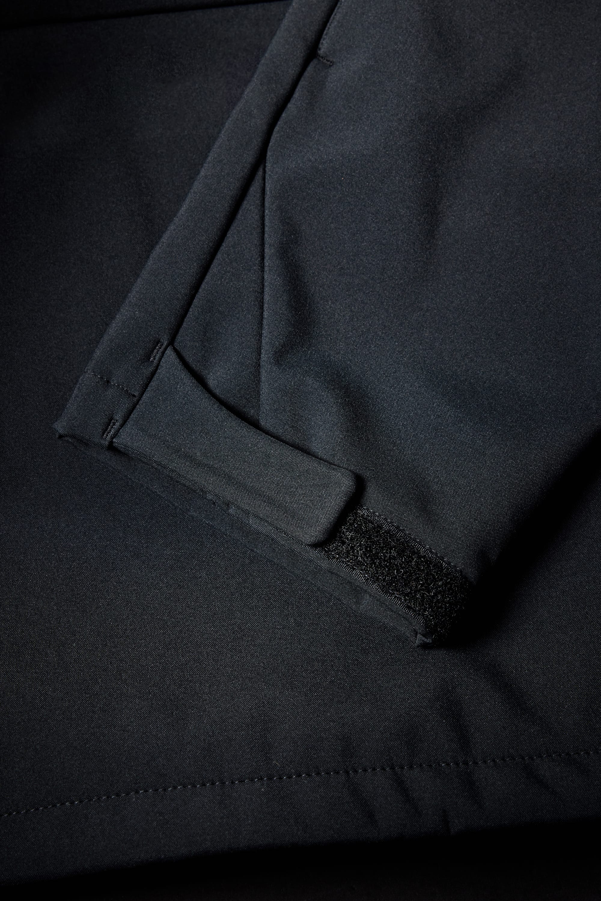 Close-up of the 686 Mens Waterproof Hoody sleeve, featuring a Velcro strap for cuff adjustment, visible pocket detail, and precise stitching.