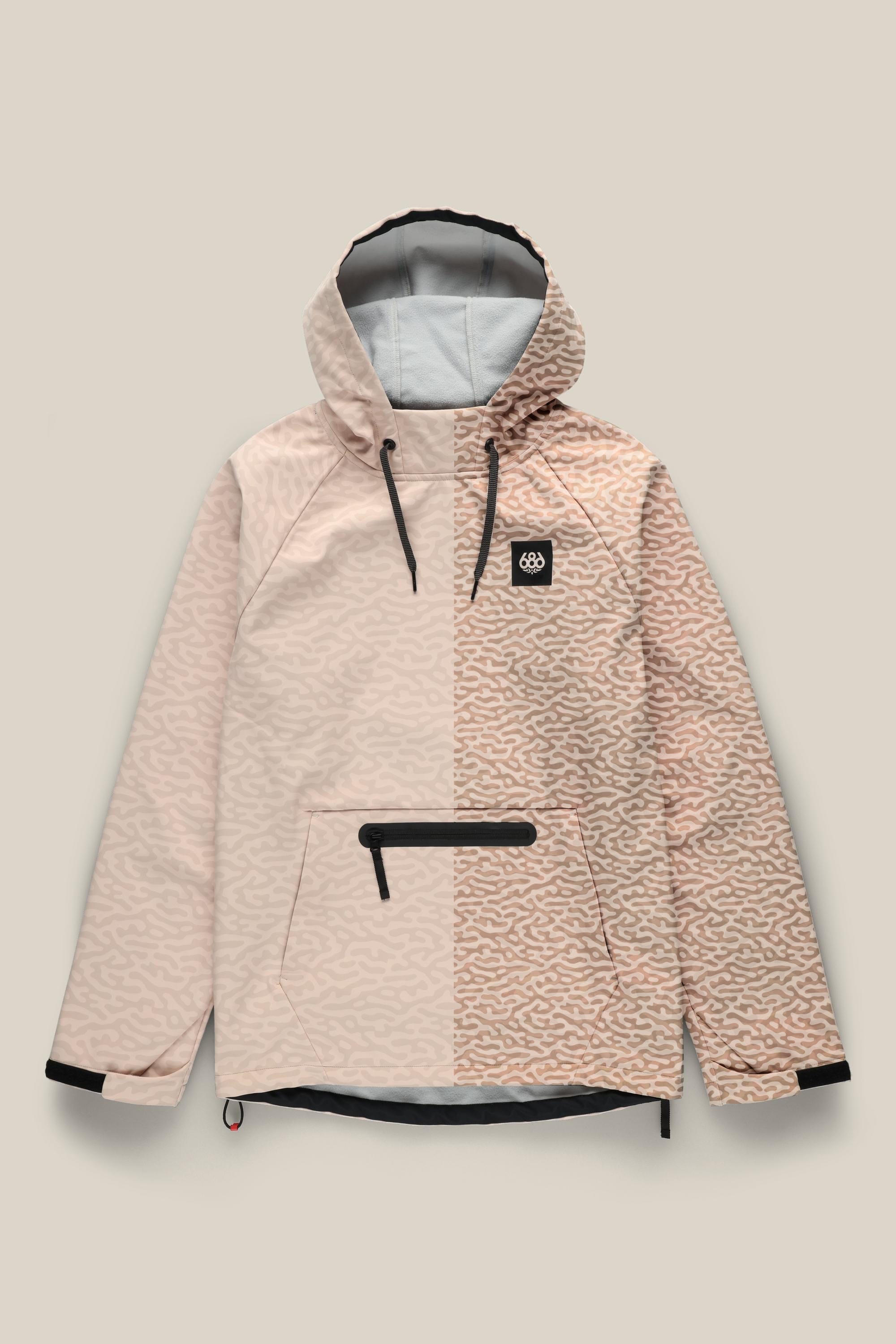 The 686 Mens Waterproof Hyperchromic Pullover Hoody features a light pink half-and-half design—solid on the left, wavy abstract print on the right—10k waterproofing, black details, front zip pocket, and chest logo patch.