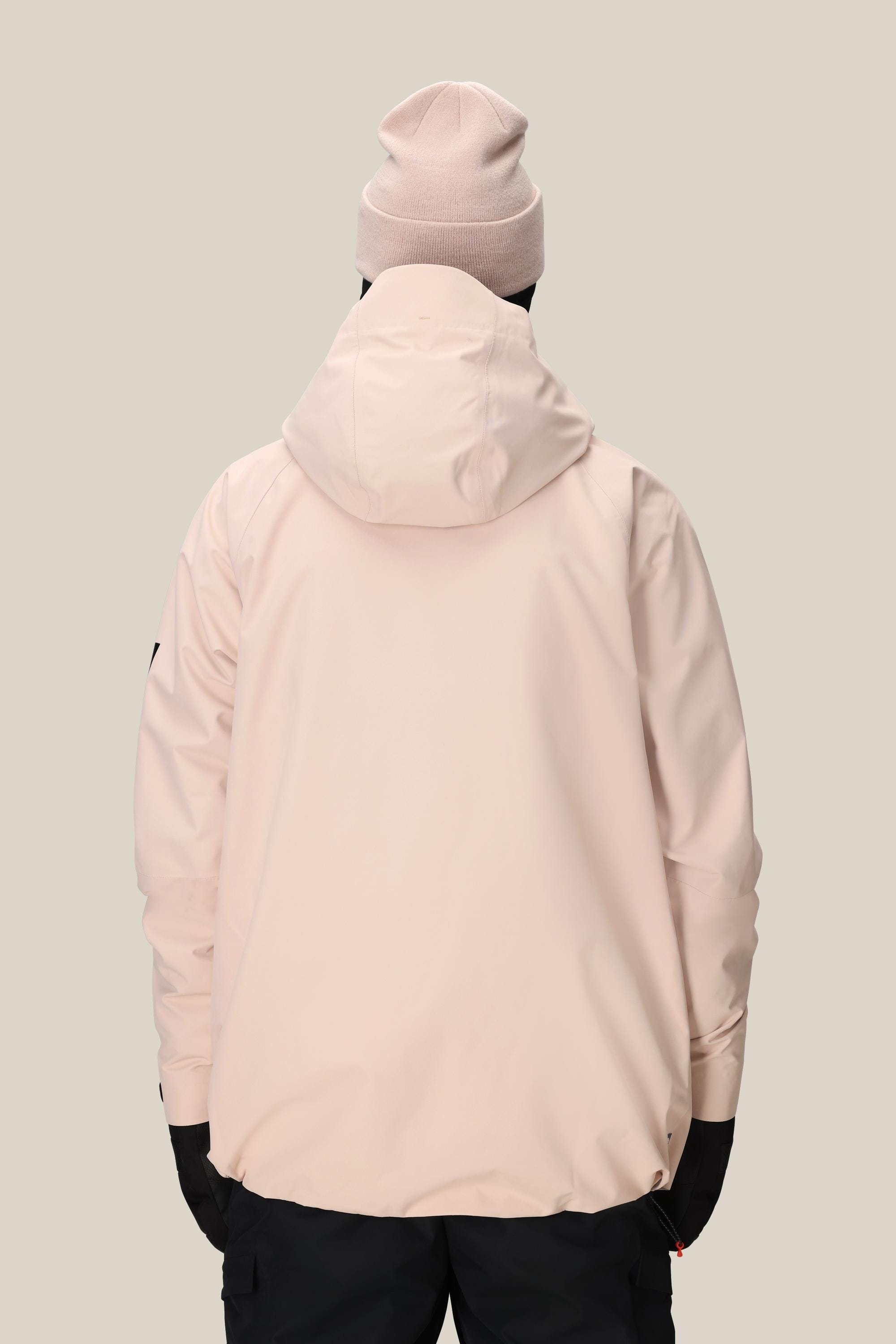 A person wearing the 686 Men's Hydra™ Thermagraph® Jacket in light pink, a matching beanie, and black pants stands with their back to the camera against a plain beige background.