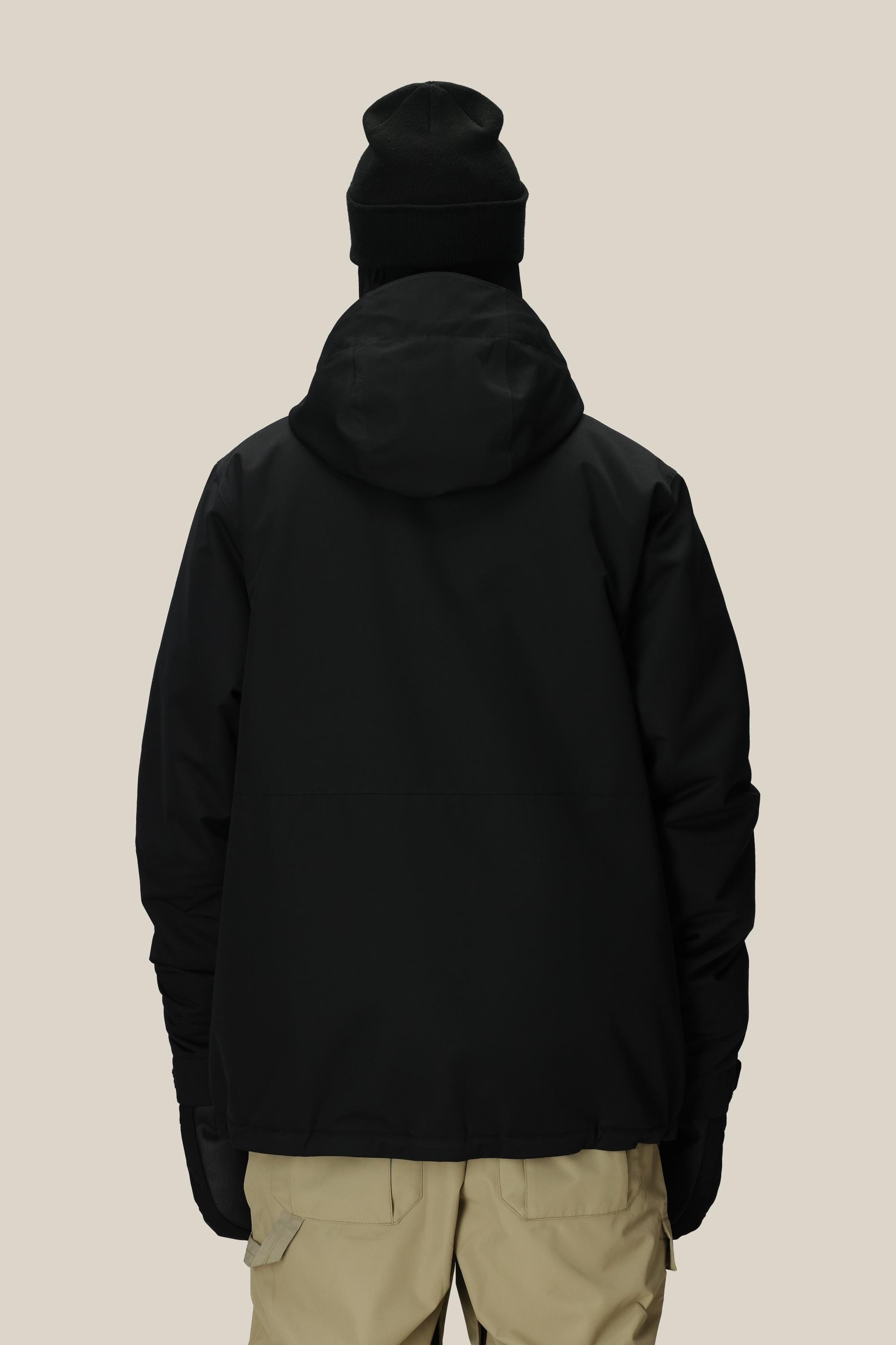 A person is shown from the back against a plain light background wearing the 686 Men's Foundation™ Insulated Jacket, a black hooded polyester jacket by 686, paired with a black beanie, black gloves, and beige pants.