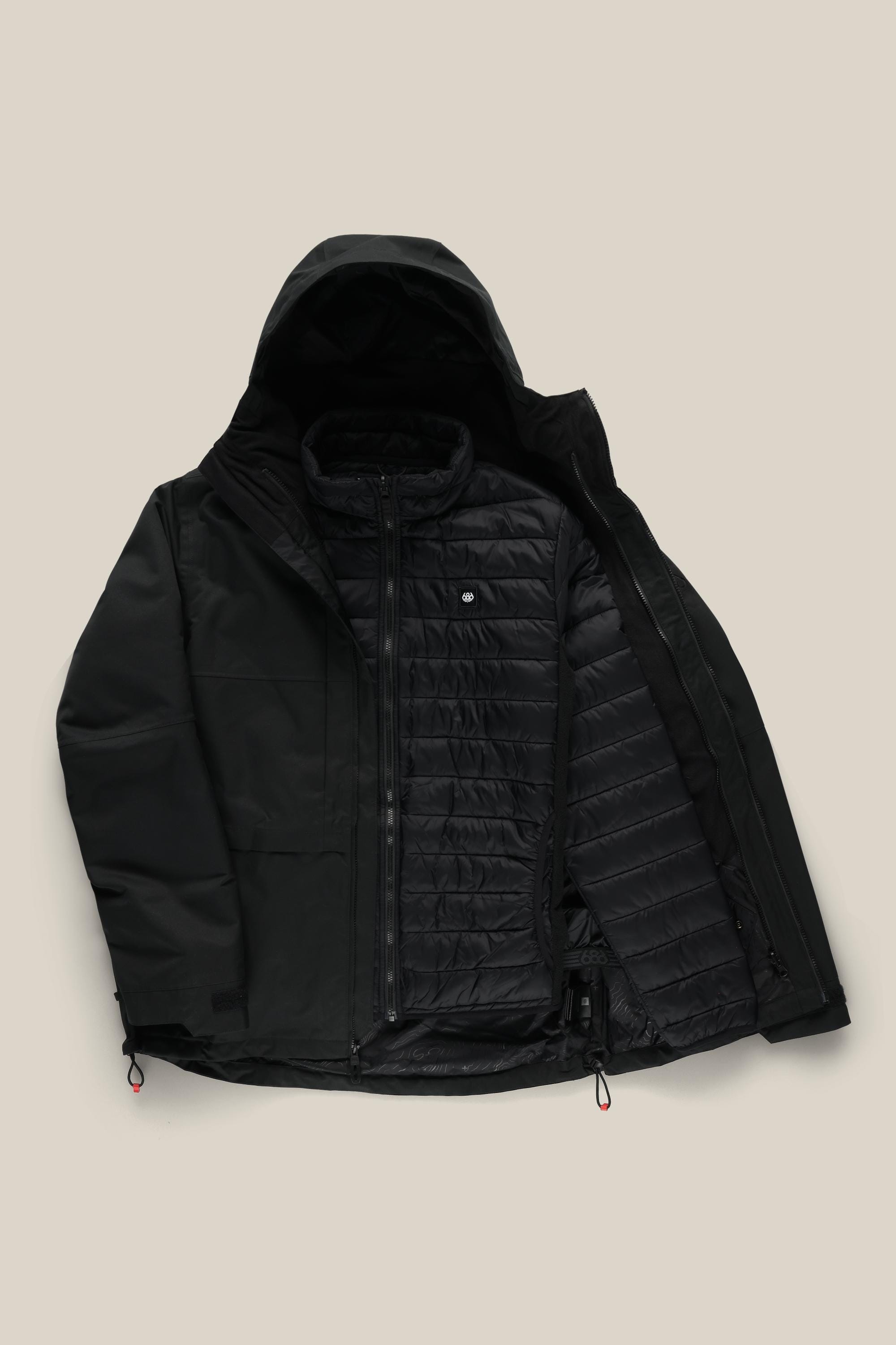 686 Men’s SMARTY® 3-In-1 Form Jacket by 686, featuring a black hooded design with a zippered front partially open to show the quilted, insulated inner layer, displayed against a light beige background.