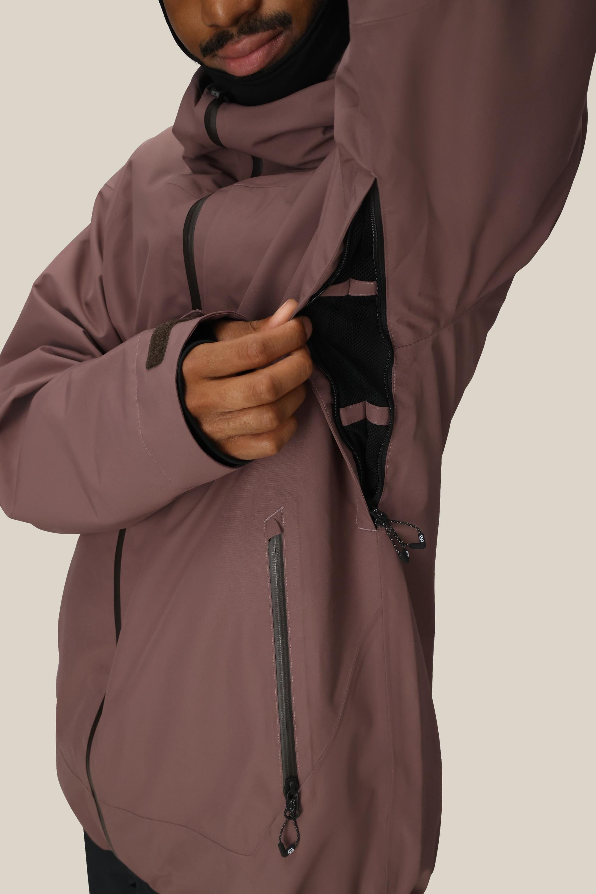 A person wearing the 686 Mens Gateway Shell Jacket unzips a black mesh-lined underarm vent, revealing the interior. Only the lower part of their face is visible.