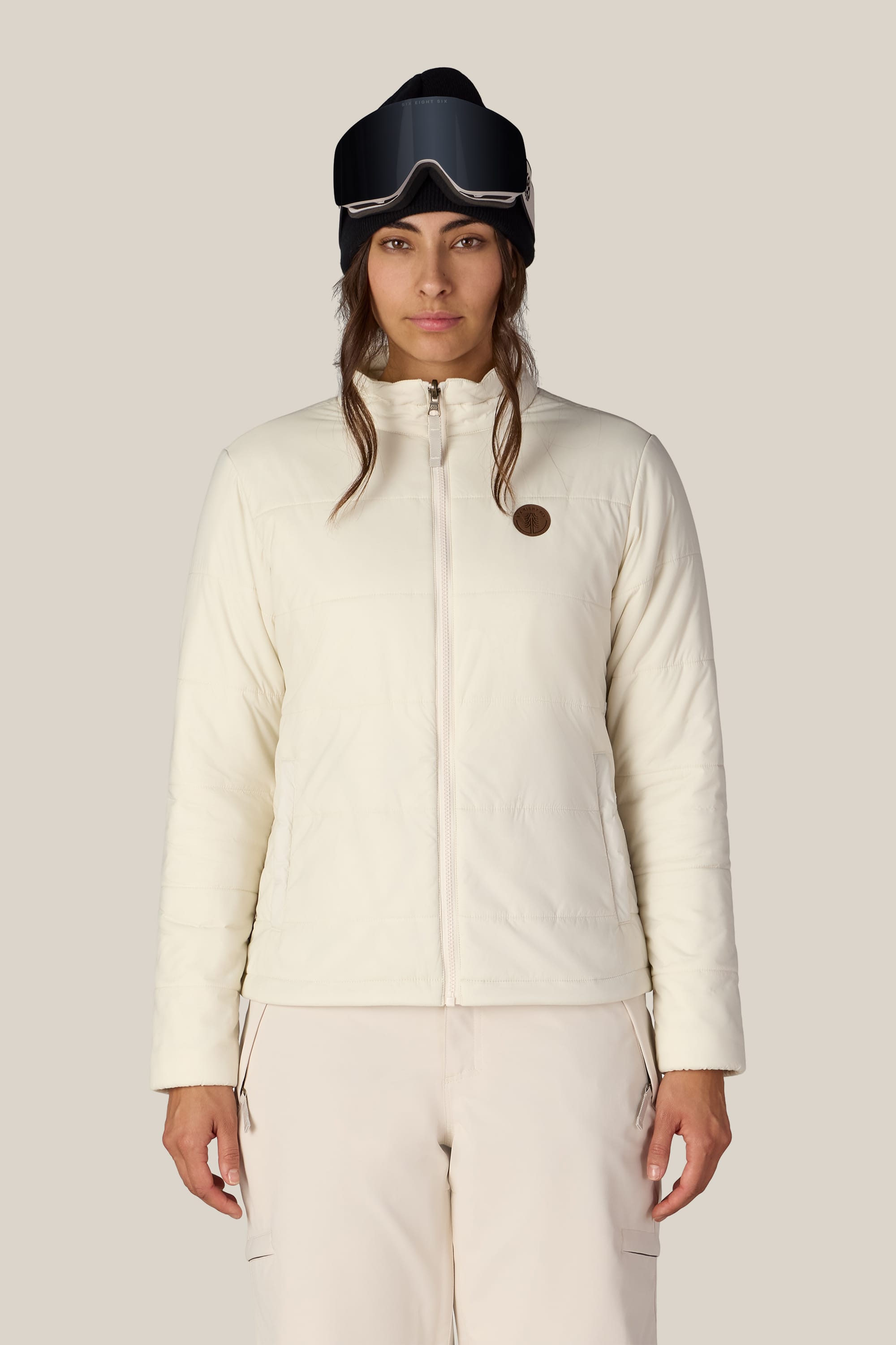 A woman wearing the 686 Women’s SMARTY® 3-In-1 Spellbound Jacket by 686 stands facing forward against a plain background.