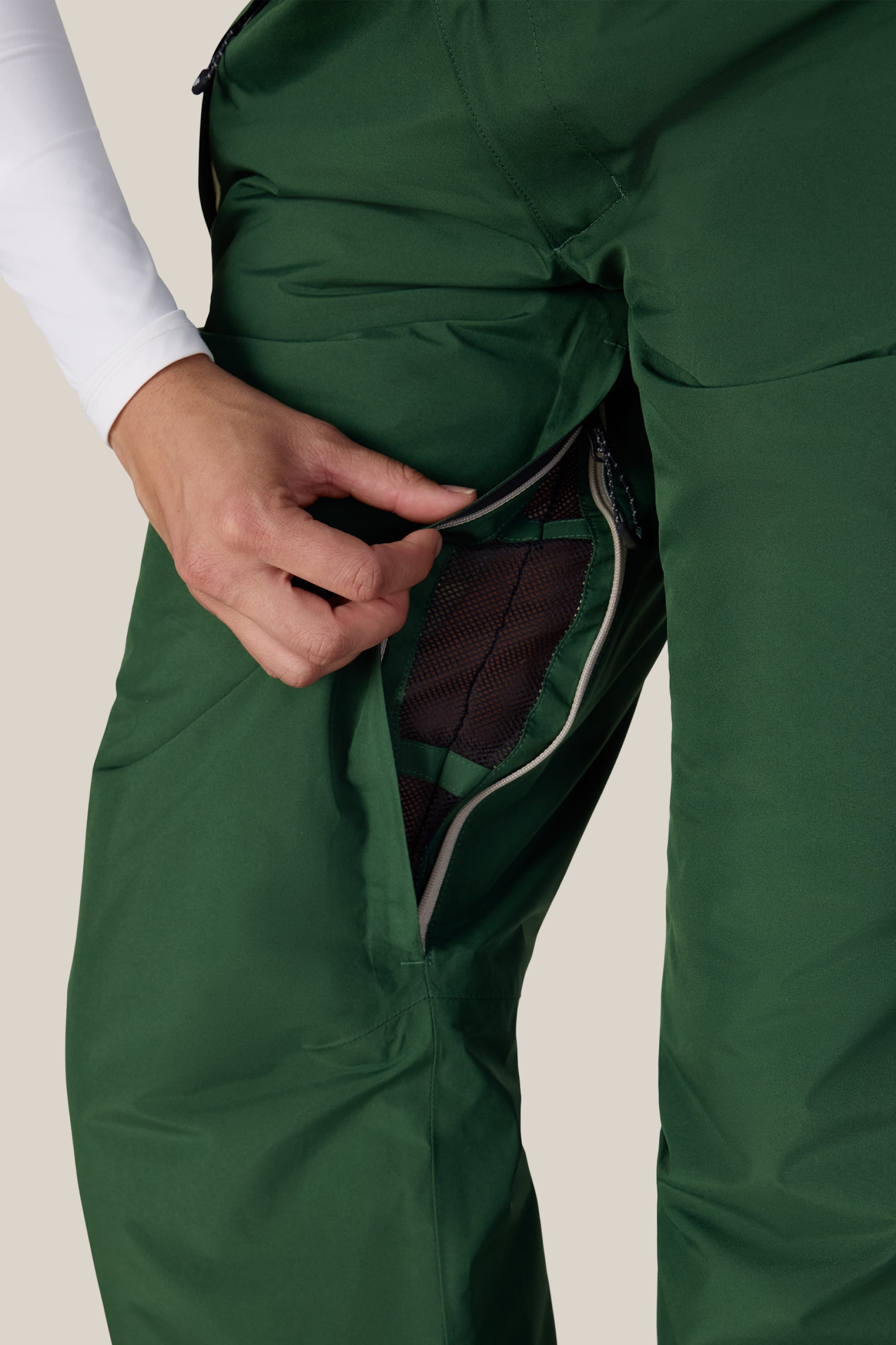 A person opens a zippered mesh vent on the thigh of the 686 Women’s GORE-TEX® Willow™ Insulated Pant, revealing the interior lining.