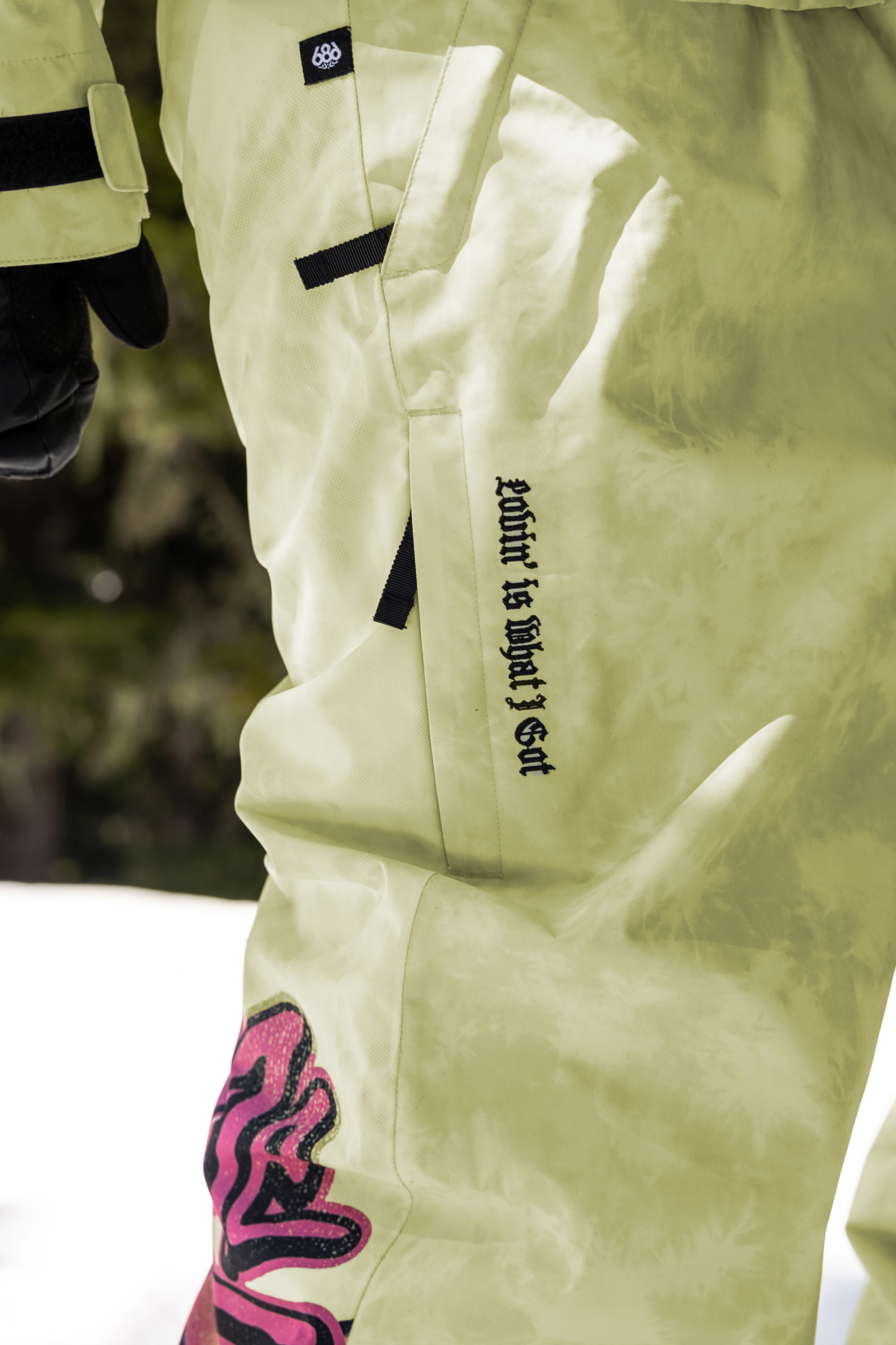 A person wearing a white snow suit paired with 686 Womens Sublime Shell Pant by 686.