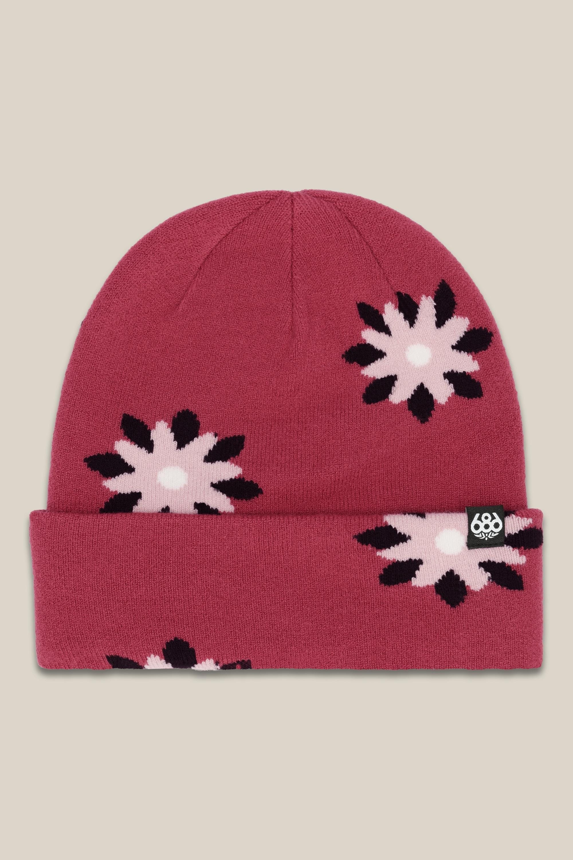 The 686 Womens Dazey Beanie is a red acrylic knit hat with a folded brim, pink and black flower pattern, and a small black tag with the white 686 logo—perfect for stylish womens winter wear.