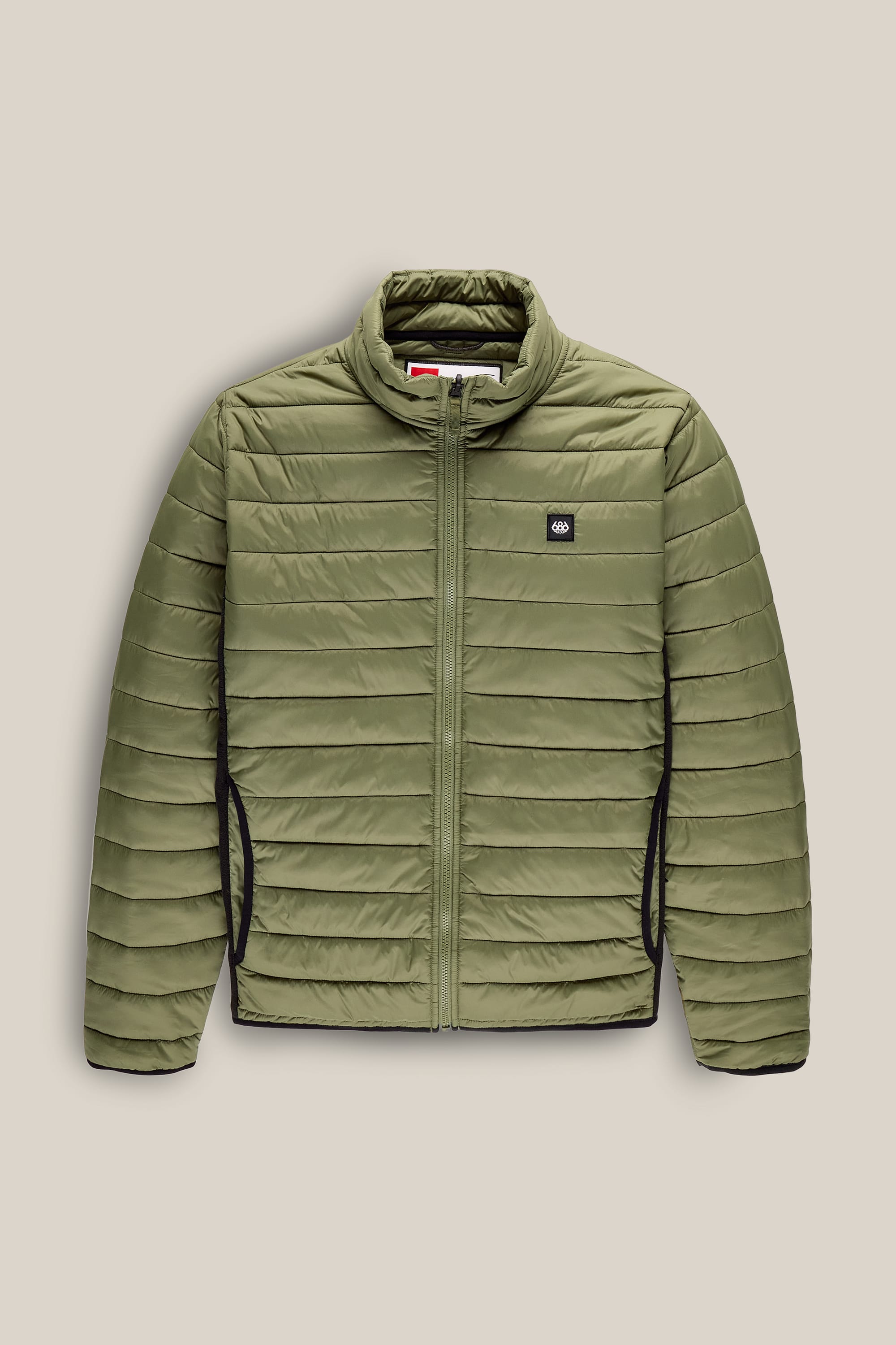 The 686 Men’s Thermal Puff Jacket by 686 is an olive green quilted jacket featuring a front zipper, stand-up collar, and side pockets. It has horizontal stitching, a small logo patch on the left chest, and is set against a beige background.