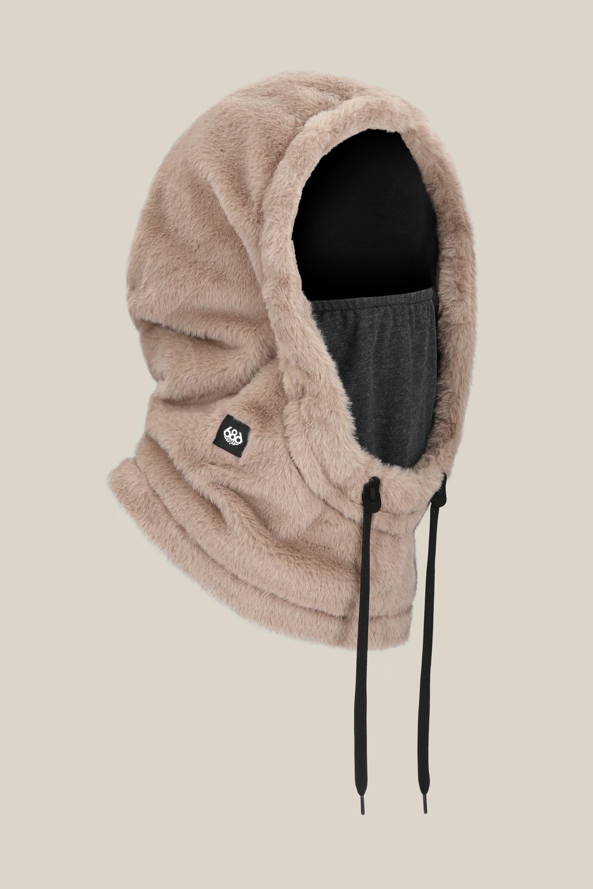 The 686 Tarmac Faux Fur Hood by 686 features tan polyester knit with a black drawstring, attached dark gray unisex facemask, plush texture, and a small logo patch on the side. Shown against a plain light beige background.