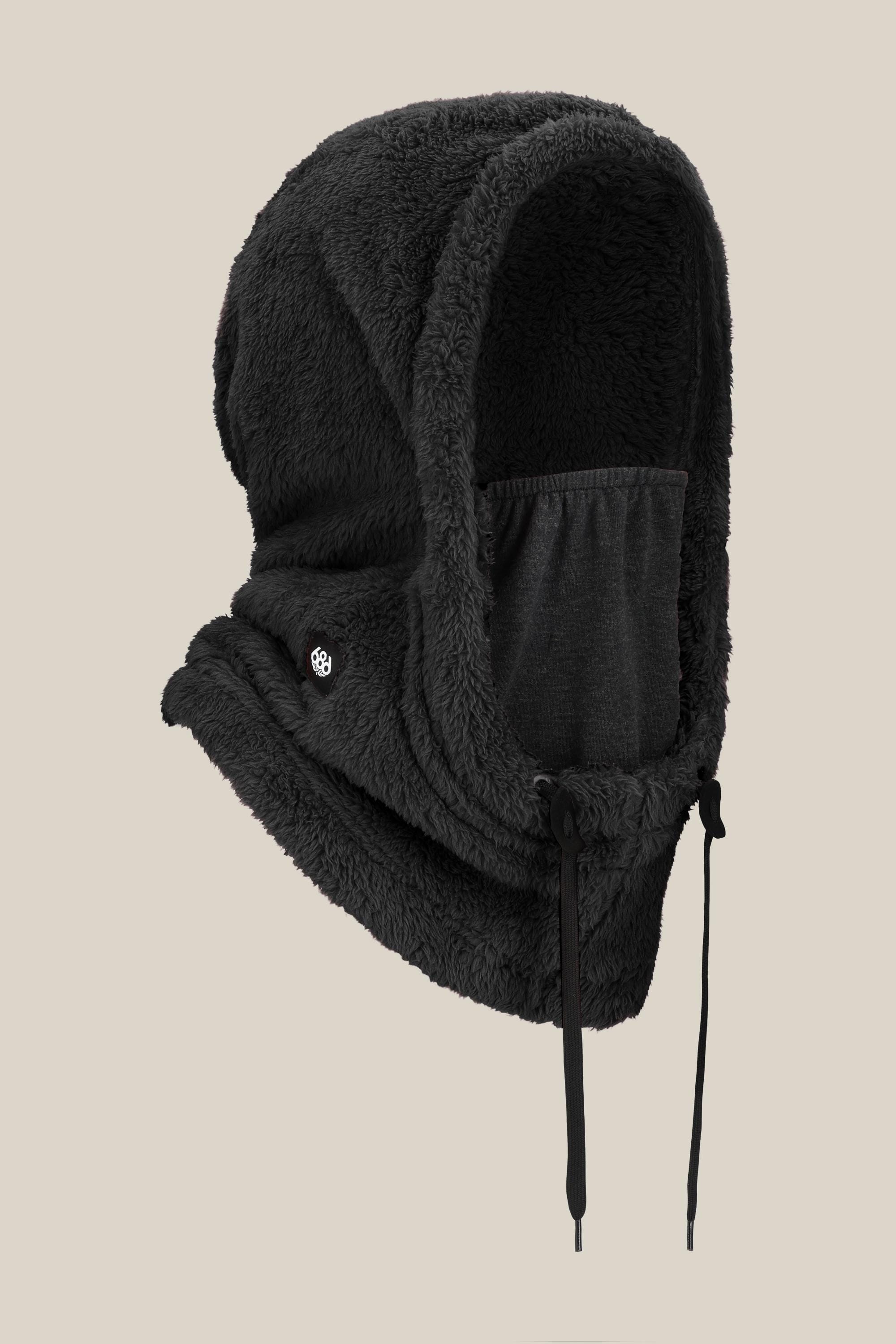The 686 Tarmac Sherpa Hood by 686 is a black, fleece-lined hooded balaclava with adjustable drawstrings and a built-in face covering, shown against a plain beige background.