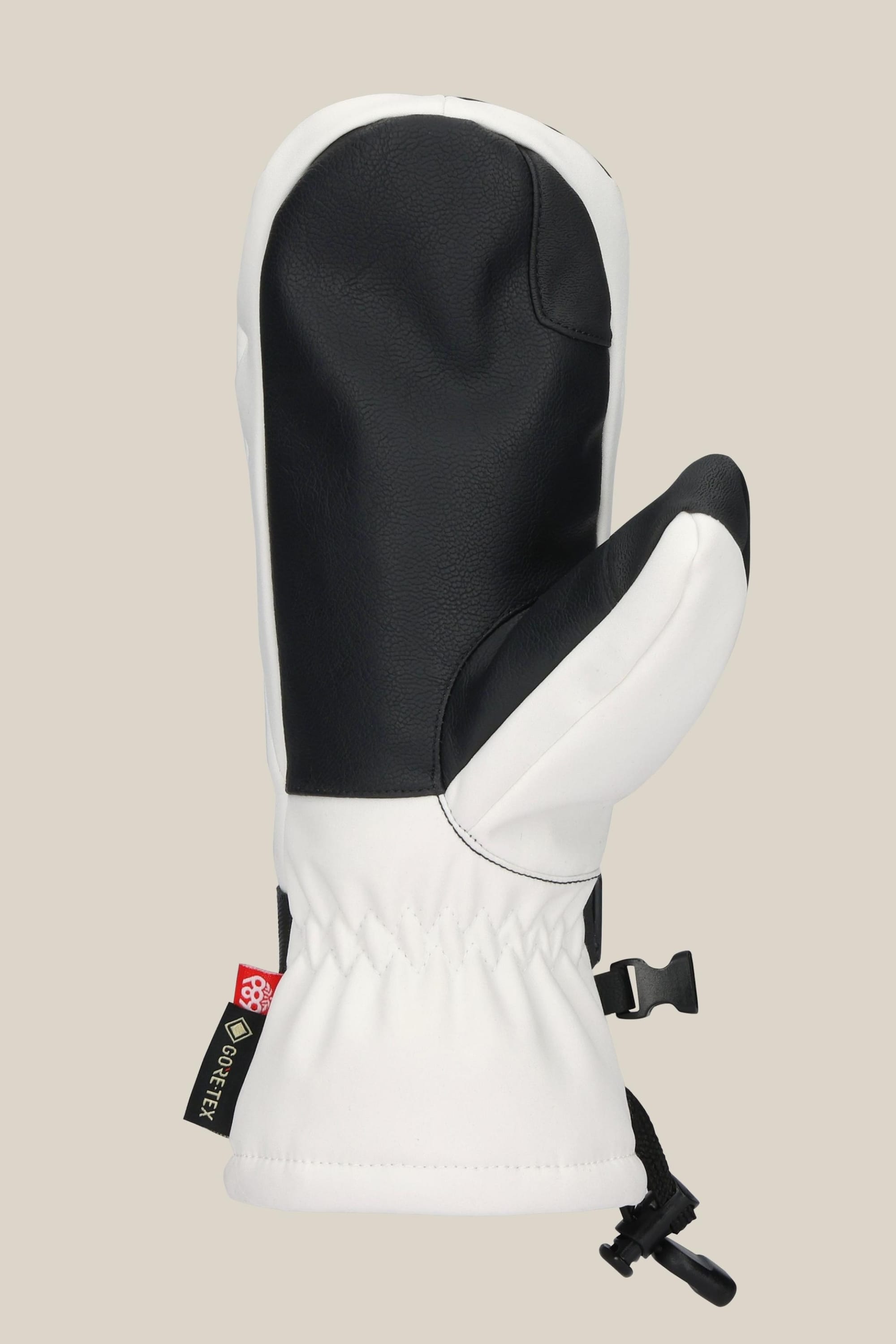 The 686 Women's GORE-TEX Linear™ Mitt by 686 is a black and white poly-fabric mitt with PU accents, gathered wrist, adjustable strap, and a Gore-Tex tag on the side, shown against a plain beige background.