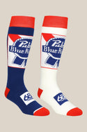 The 686 Mens PBR Socks - 2 Pack features two knee-high performance socks with Pabst Blue Ribbon logos—one in blue with red and white accents, the other in white with red and blue. 68 Degrees & Sunny appears on the foot. Brand: 686.
