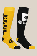 The 686 Mens Sublime Socks - 2 Pack by 686 features one yellow knee-high sock with a black checkerboard and SUBLIME text, and one black sock with a white patch and stylized Sublime. Both are acrylic, with contrasting colored toes and heels.