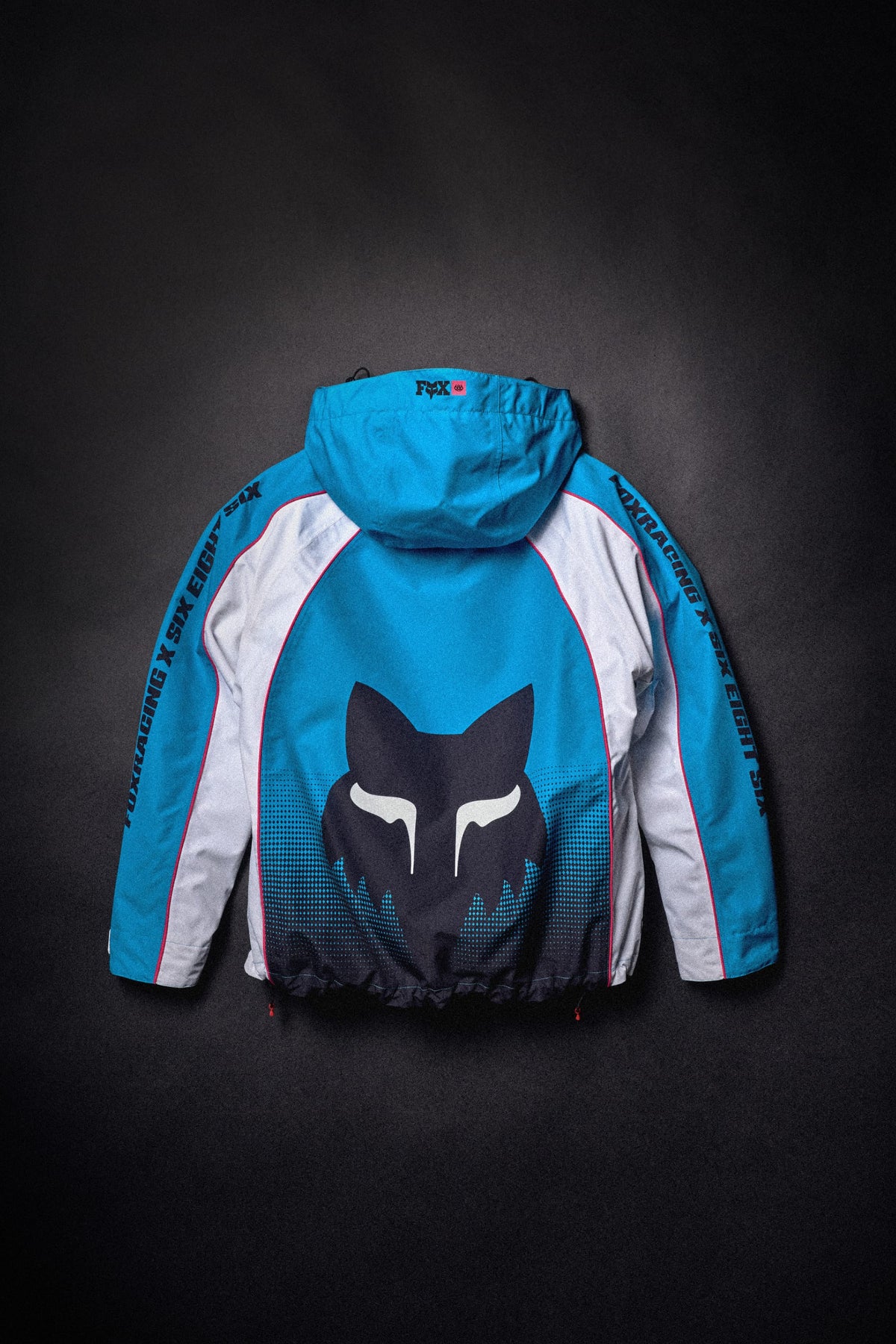 Blue and white 686 Women’s Fox Racing 97 Shell Jacket with a fox head logo on the back.