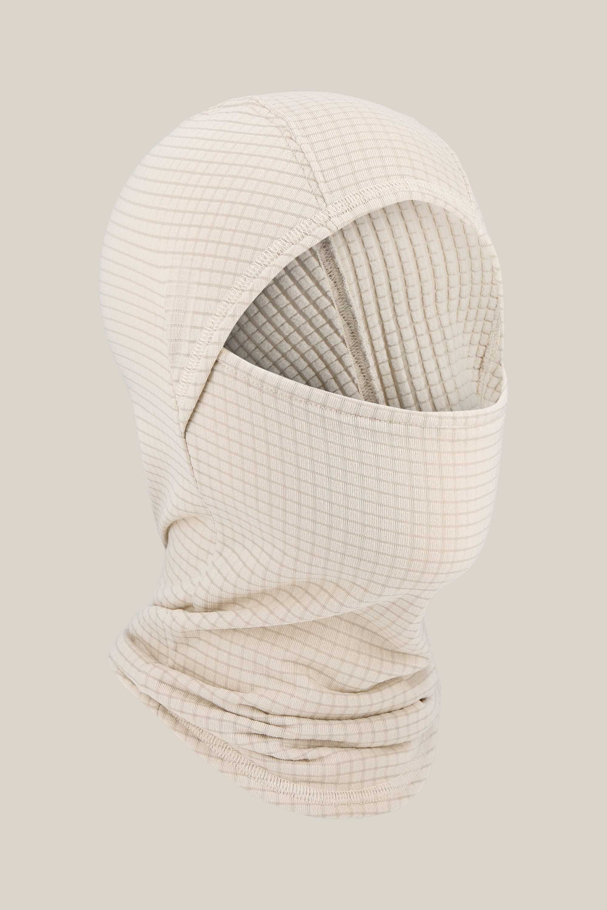 The 686 Mission Grid™ Balaclava by 686 is a beige, grid-patterned knit facemask crafted from soft merino wool, featuring an eye and nose opening and shown on a neutral background.