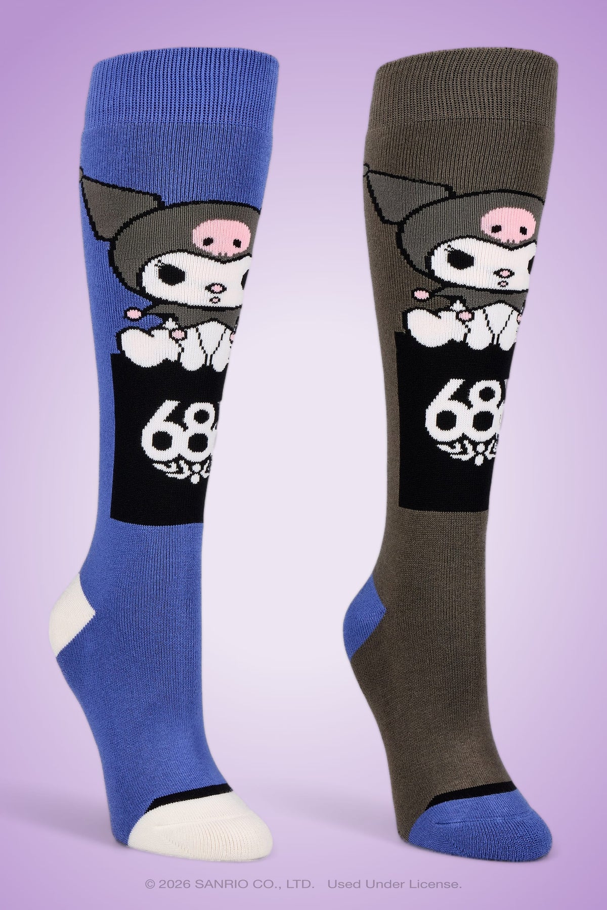 A pair of 686 Women’s Kuromi™ Socks, featuring one blue and one brown knee-high sock adorned with a cartoon character in a skull hat and a “69” graphic, displayed on a purple background.